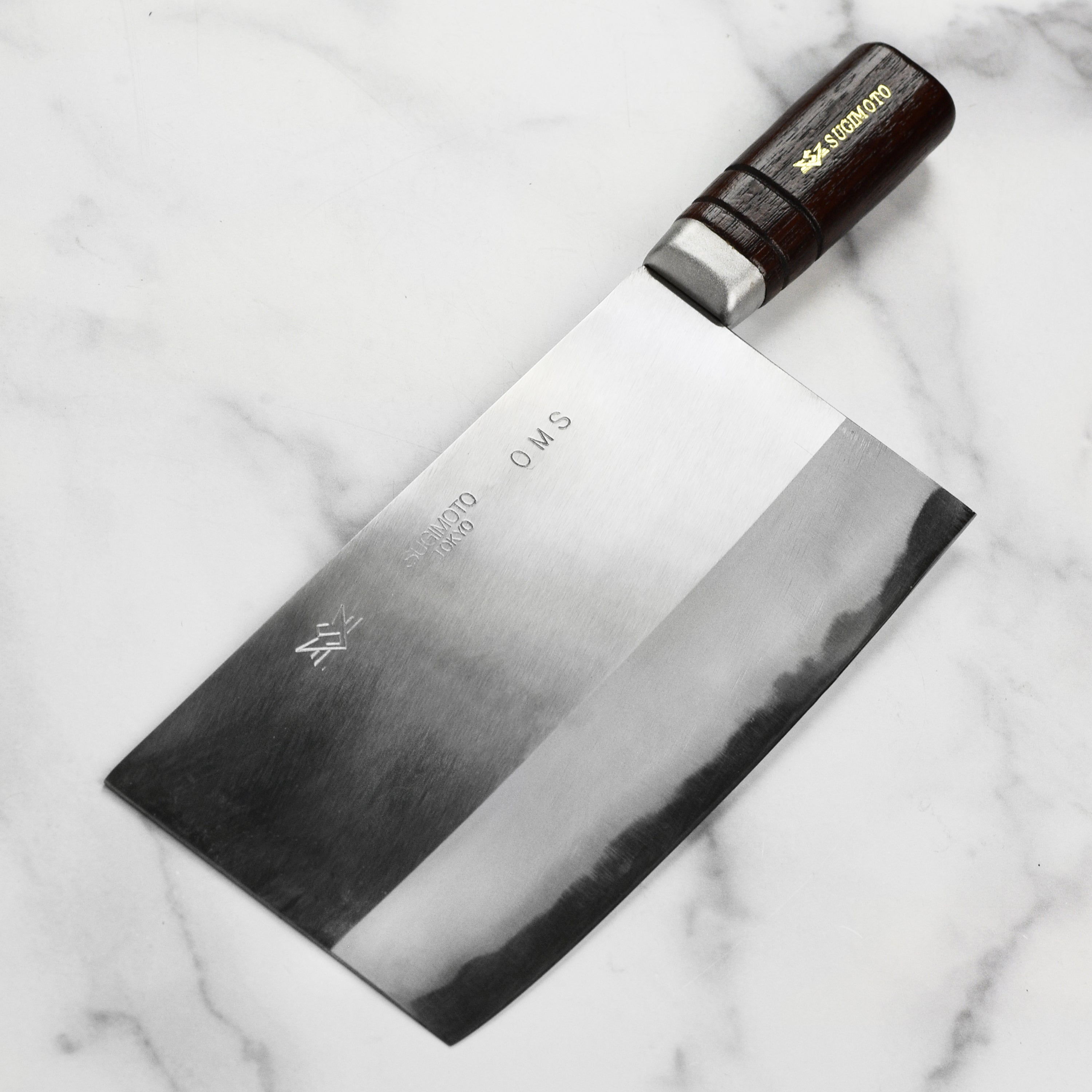 Home cook using a traditional Chinese cleaver to chop chicken on a cutting board