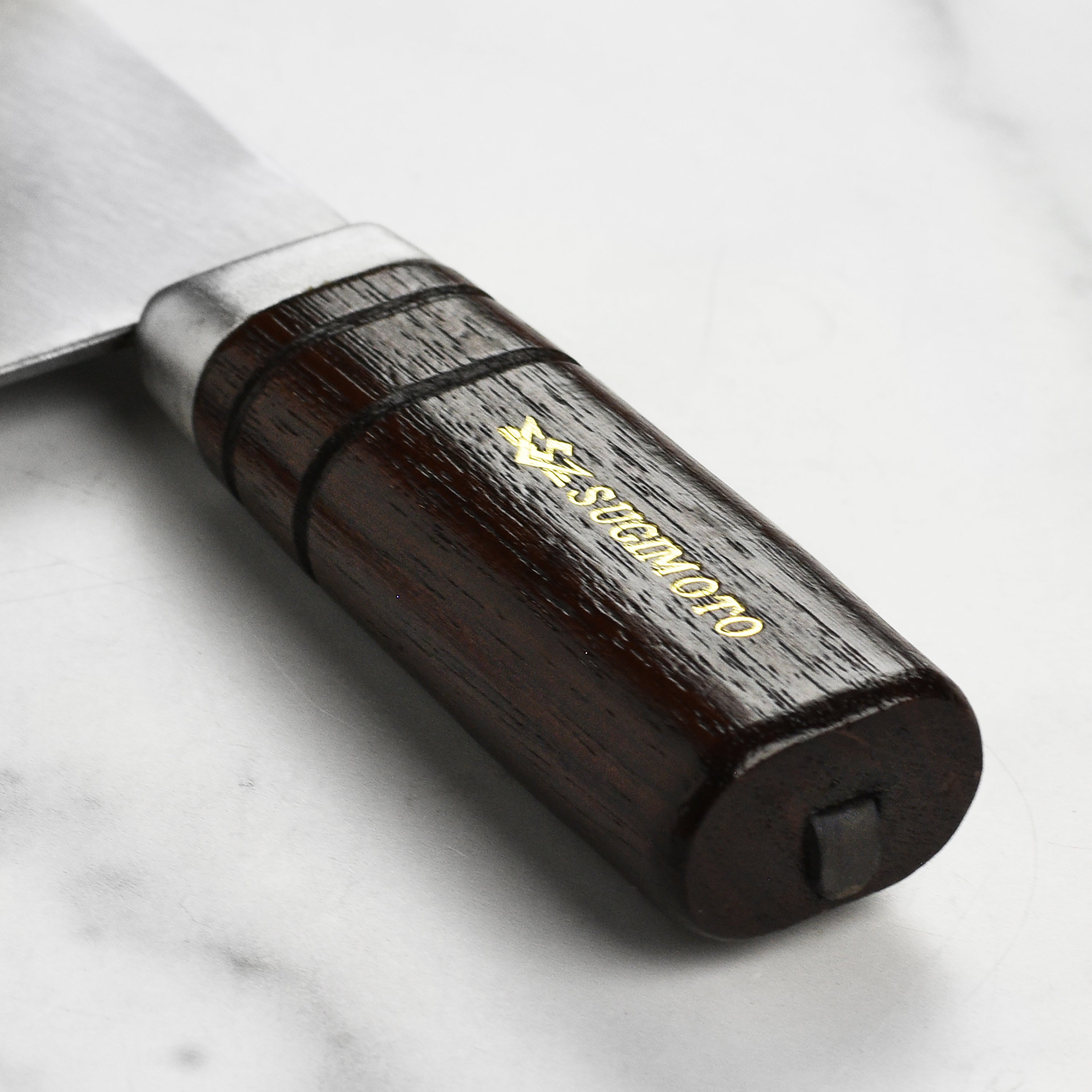 Home cook using a traditional Chinese cleaver to chop chicken on a cutting board