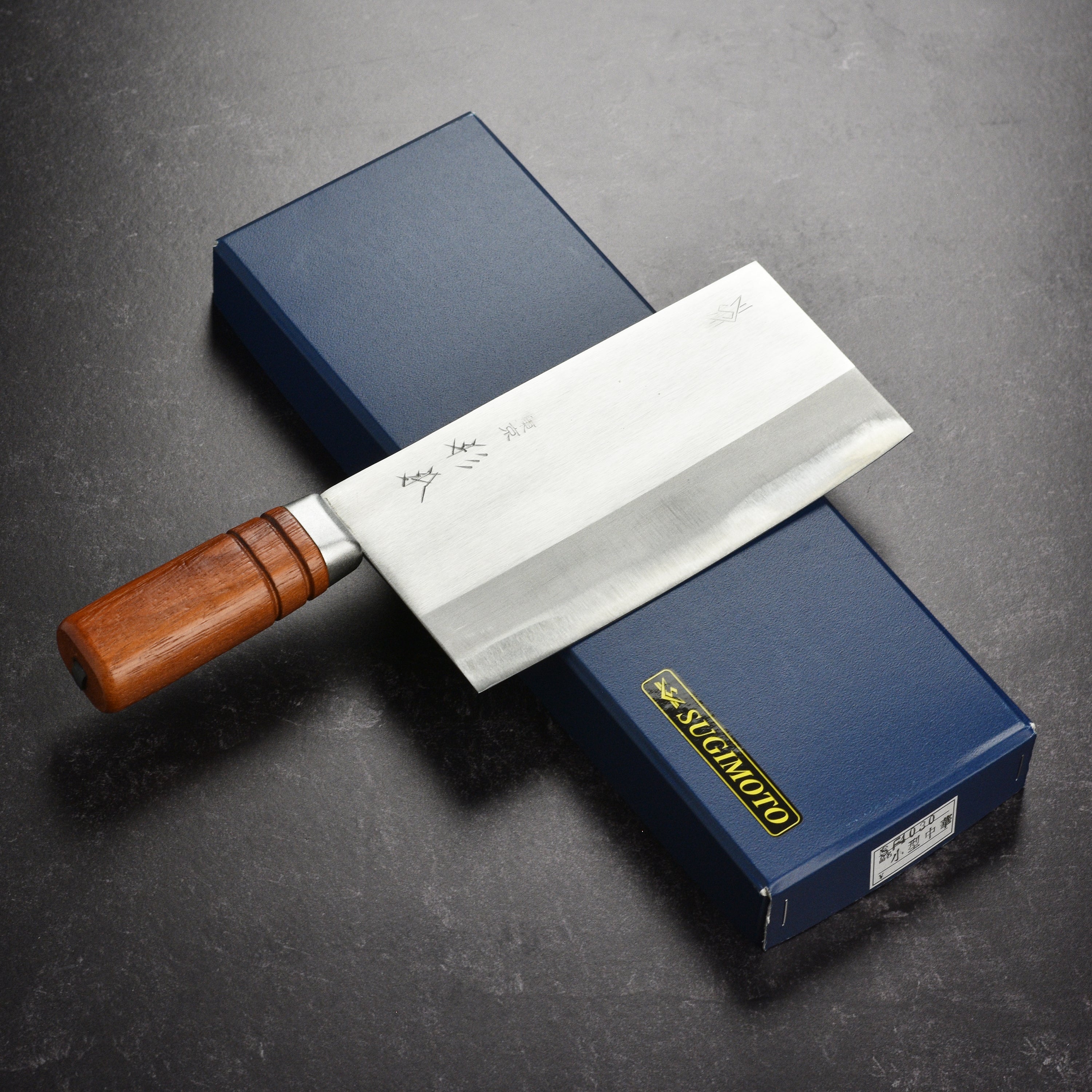 Chef using Sugimoto 7.5" Carbon Steel Cleaver to chop ingredients in the kitchen.