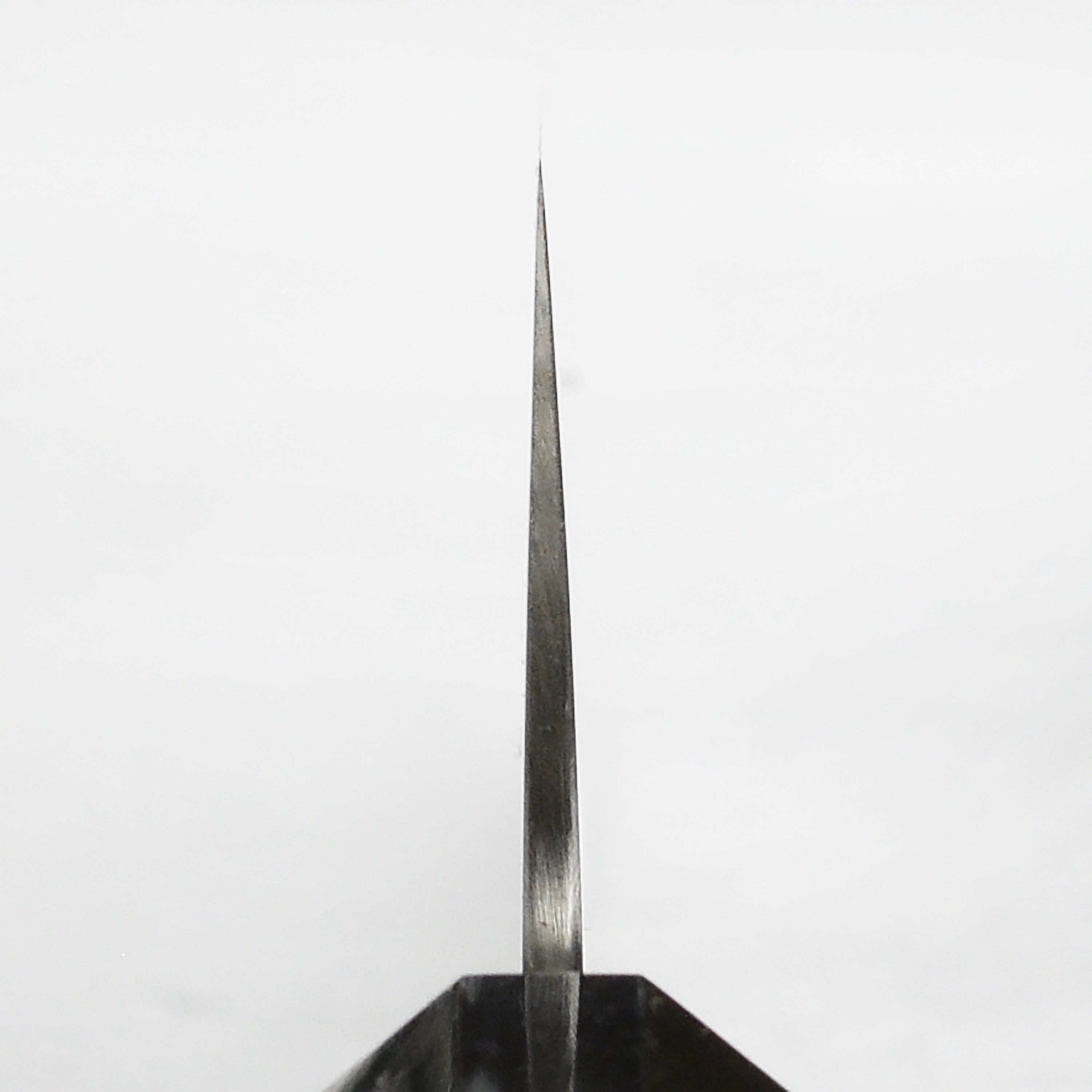 Sukenari ZDP189 Gyuto knife from a top-down angle on a wooden cutting board.