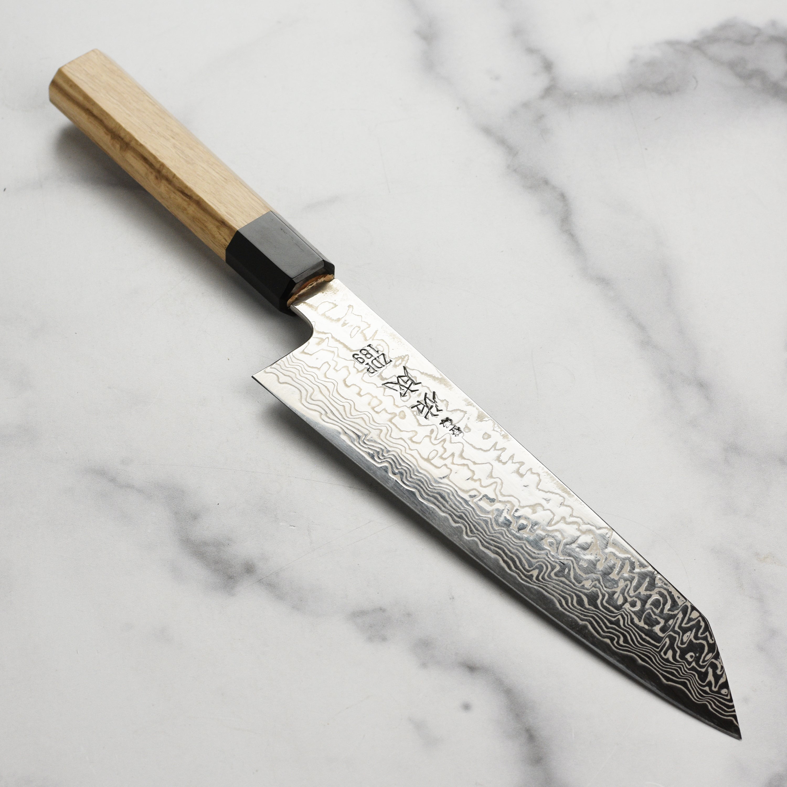 Sukenari ZDP189 Damascus knife showcasing its intricate blade design and ergonomic handle.