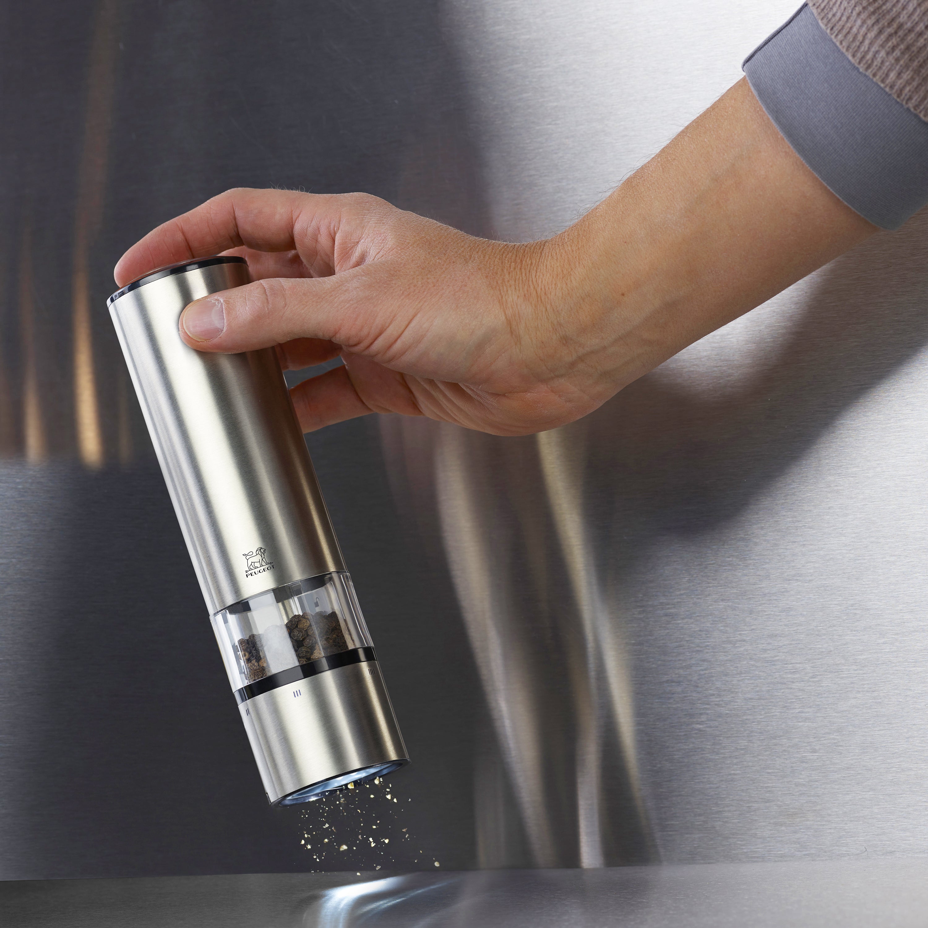 Modern kitchen setting featuring the Peugeot Elis Sense electric salt and pepper mill set