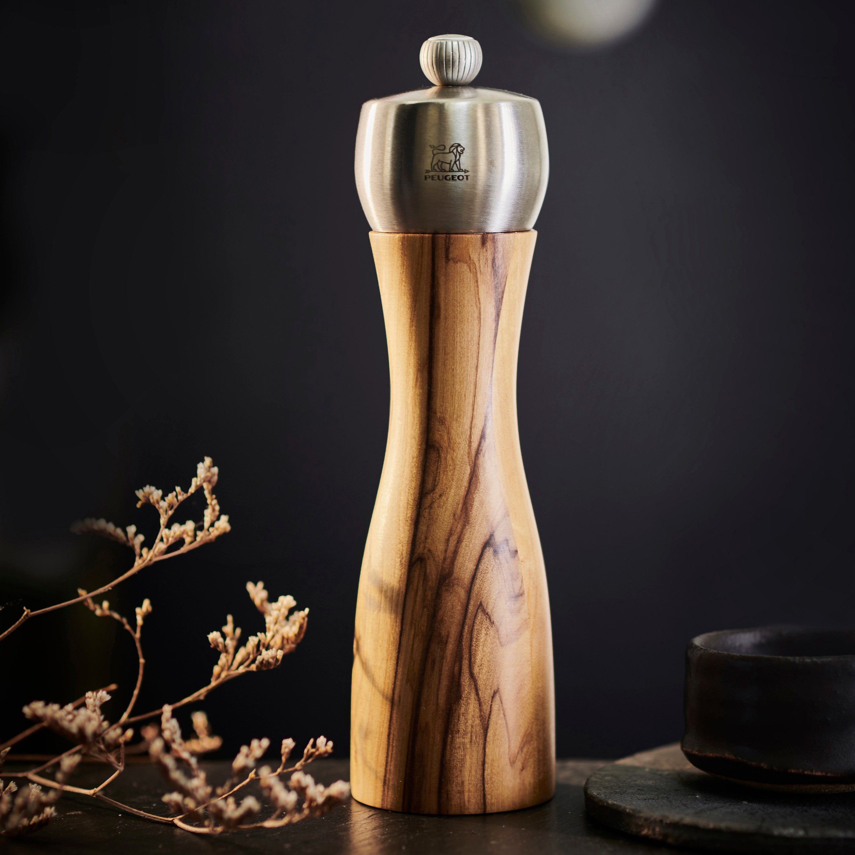 Close-up of Peugeot Fidji Olivewood Salt and Pepper Grinder Set showing the brushed stainless steel top