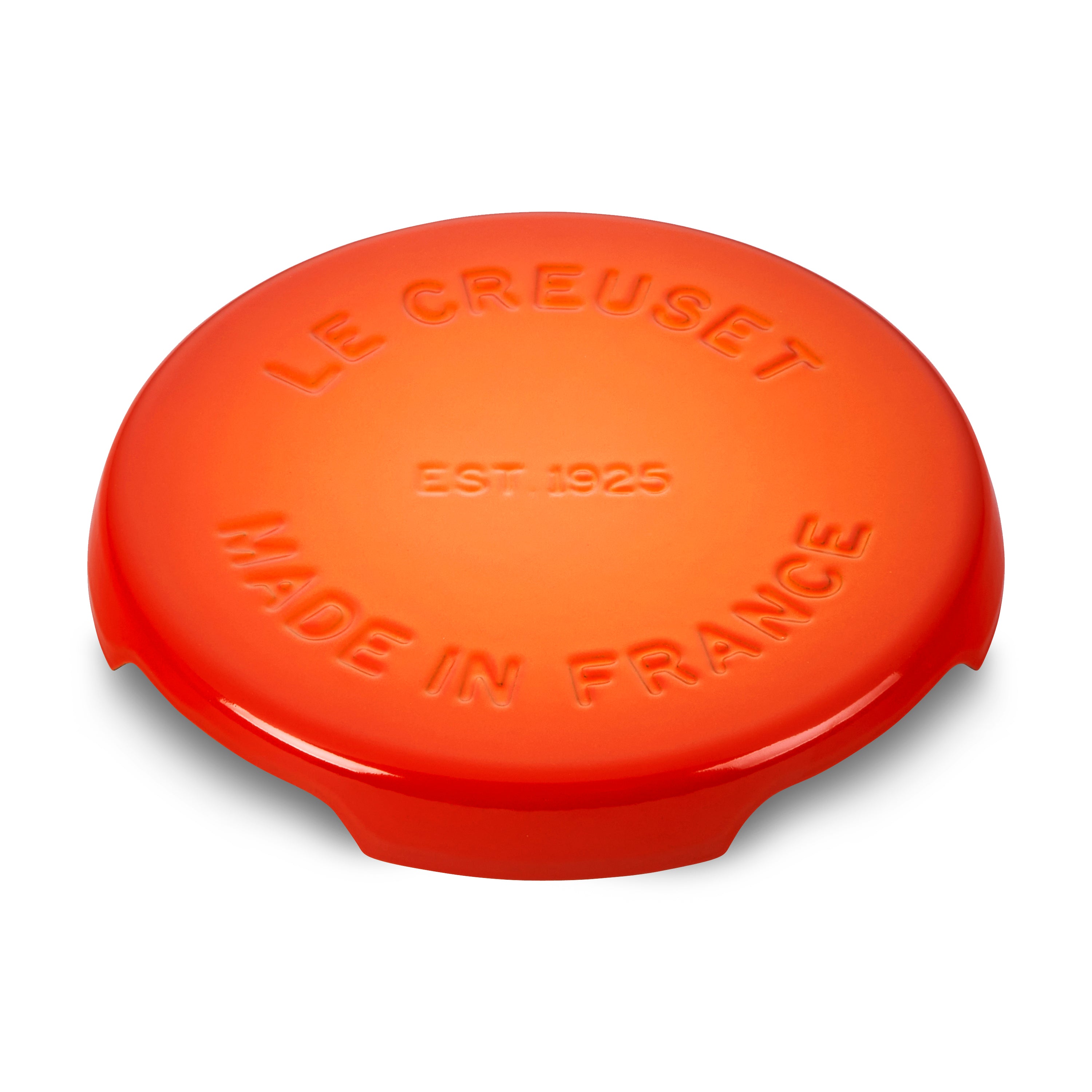 Le Creuset cast iron trivet protecting a dining table with hot dishes
