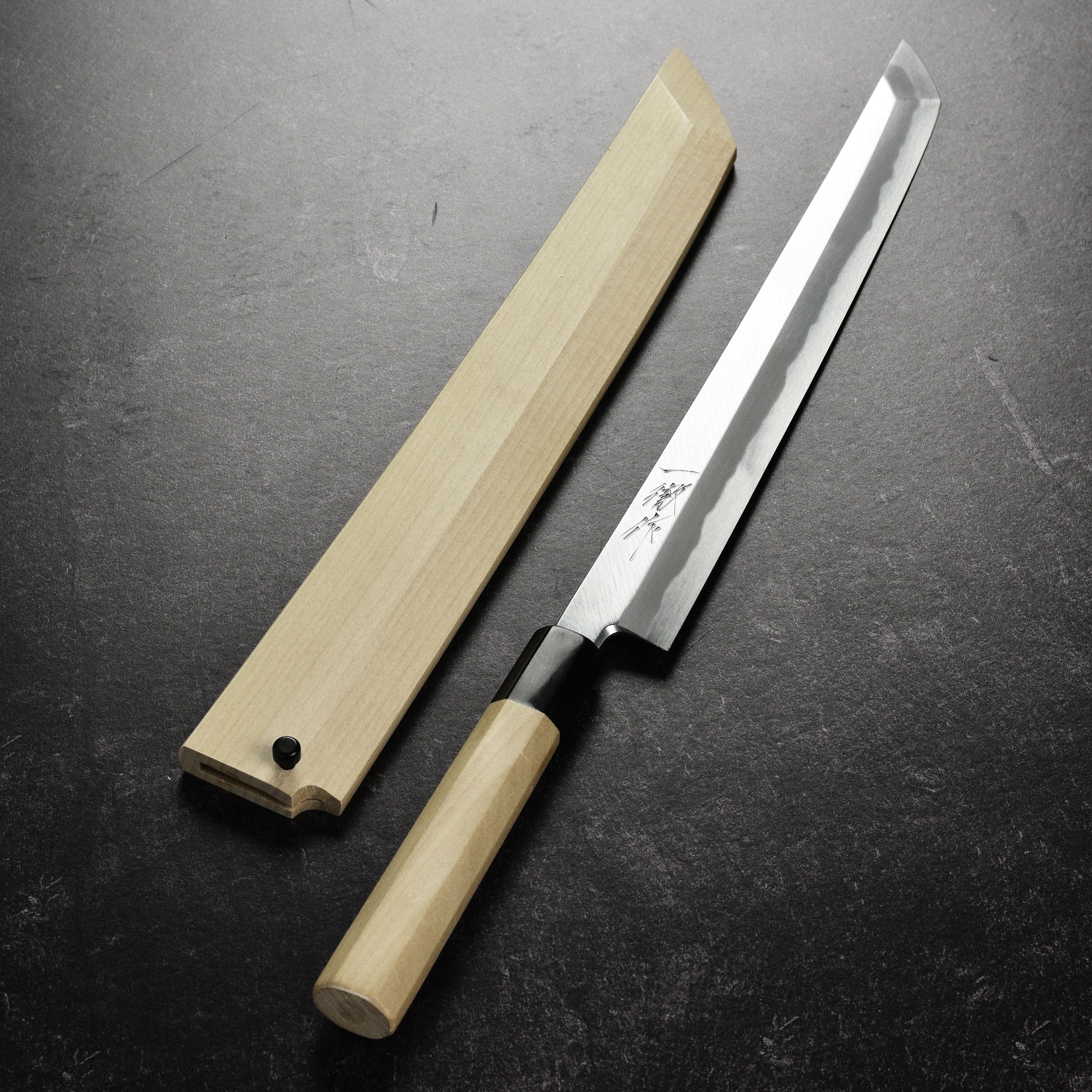 Chef using the Tanaka Shirogami #2 knife to prepare fresh sashimi, highlighting its ergonomic handle.