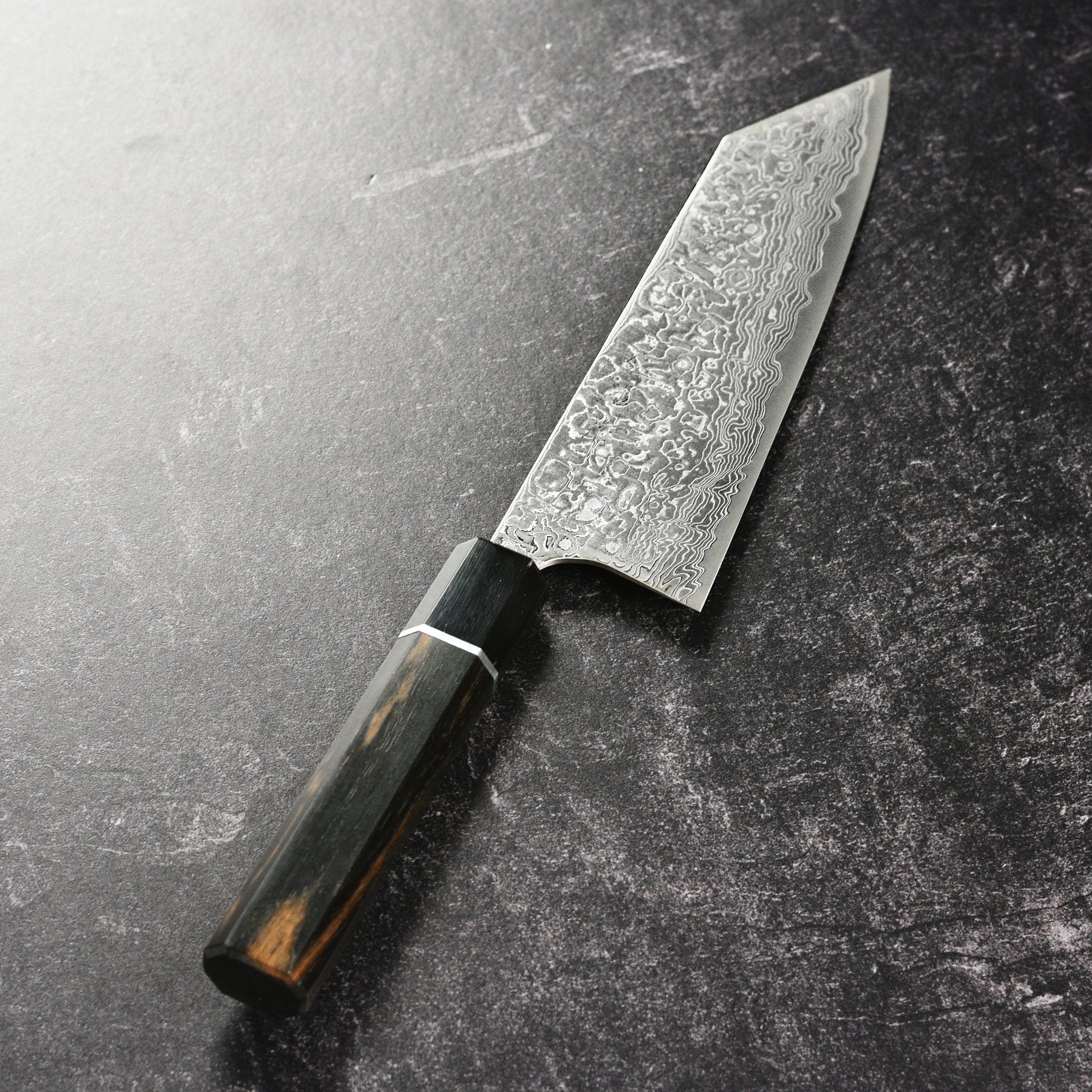 Detailed view of the octagonal ebony handle and damascus blade