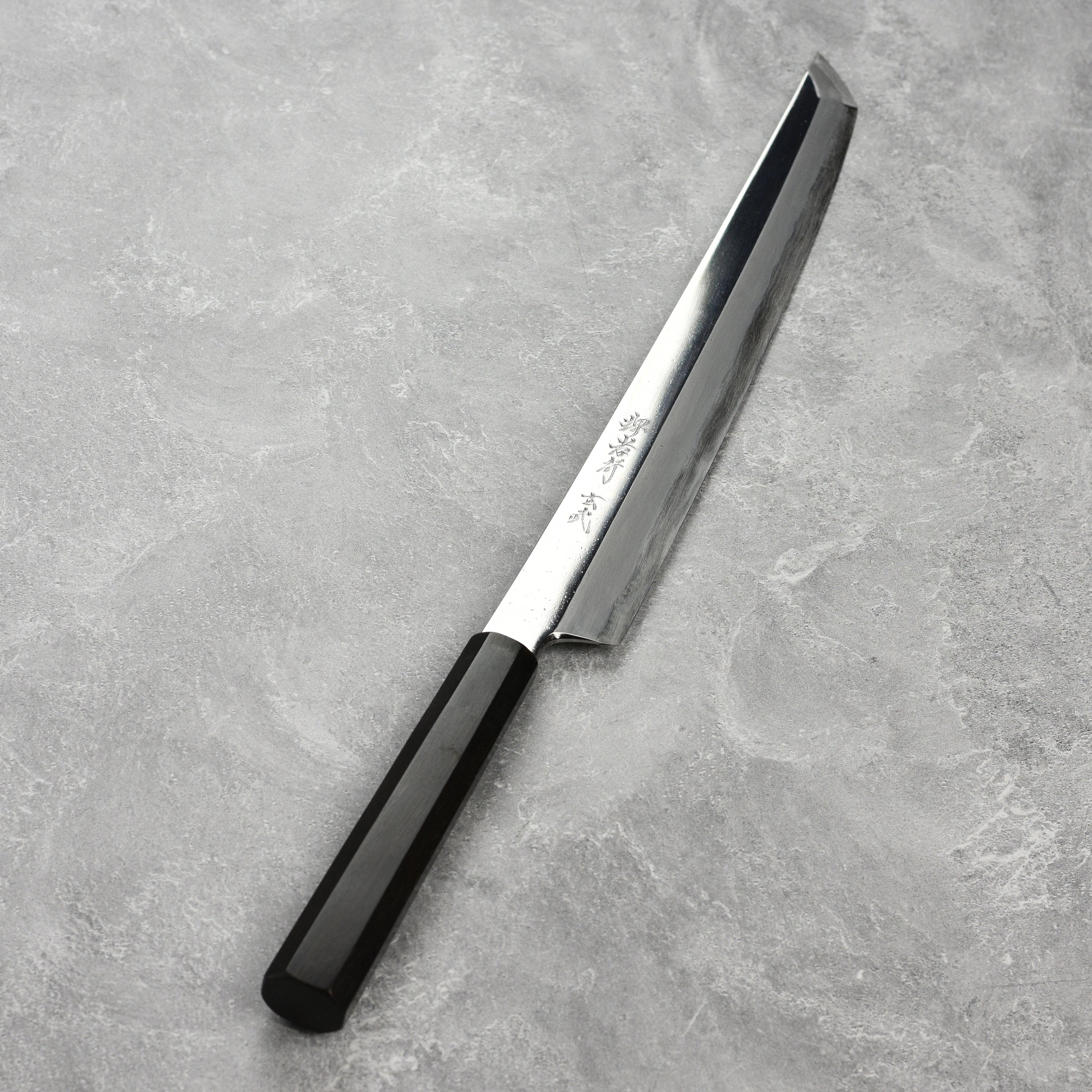 Premium chef knife with saya displayed elegantly on a kitchen countertop.