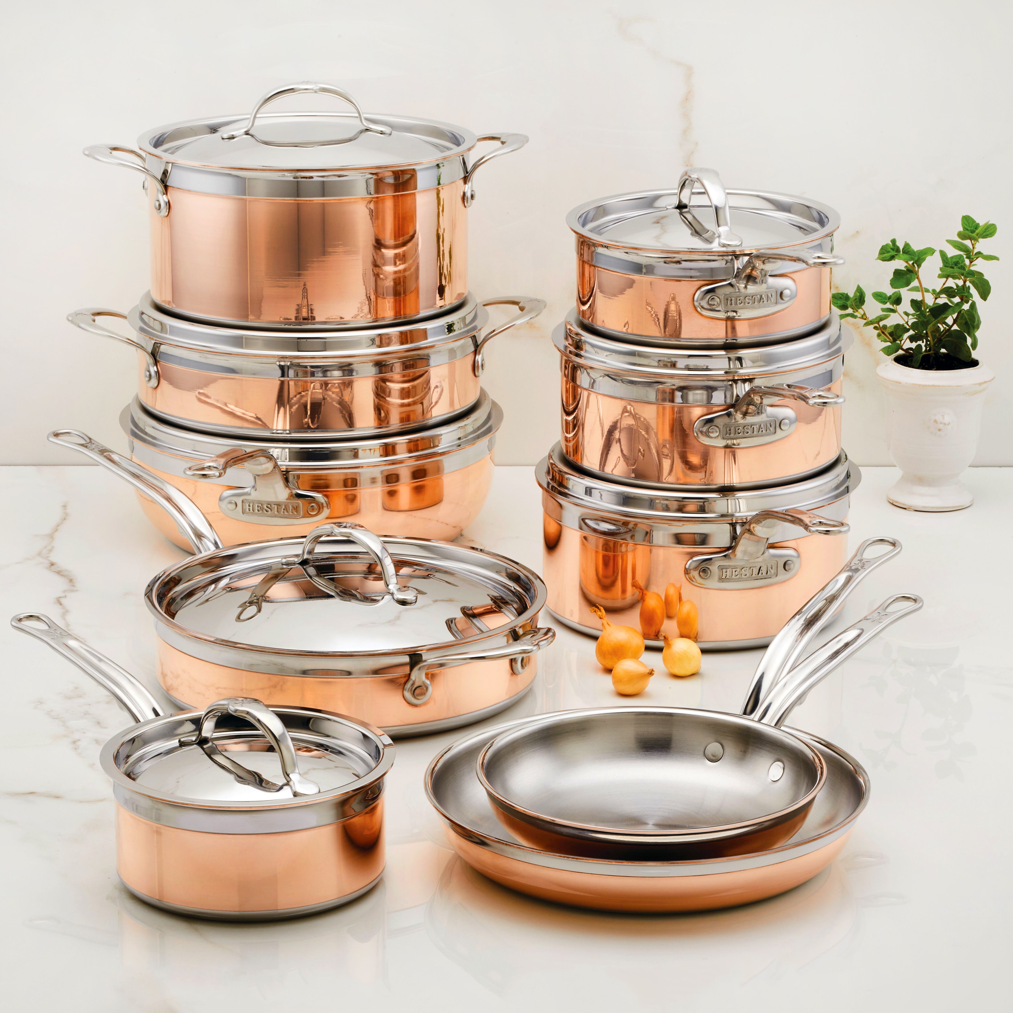 Close-up view of Hestan CopperBond induction cookware with riveted handles and polished stainless steel lid.