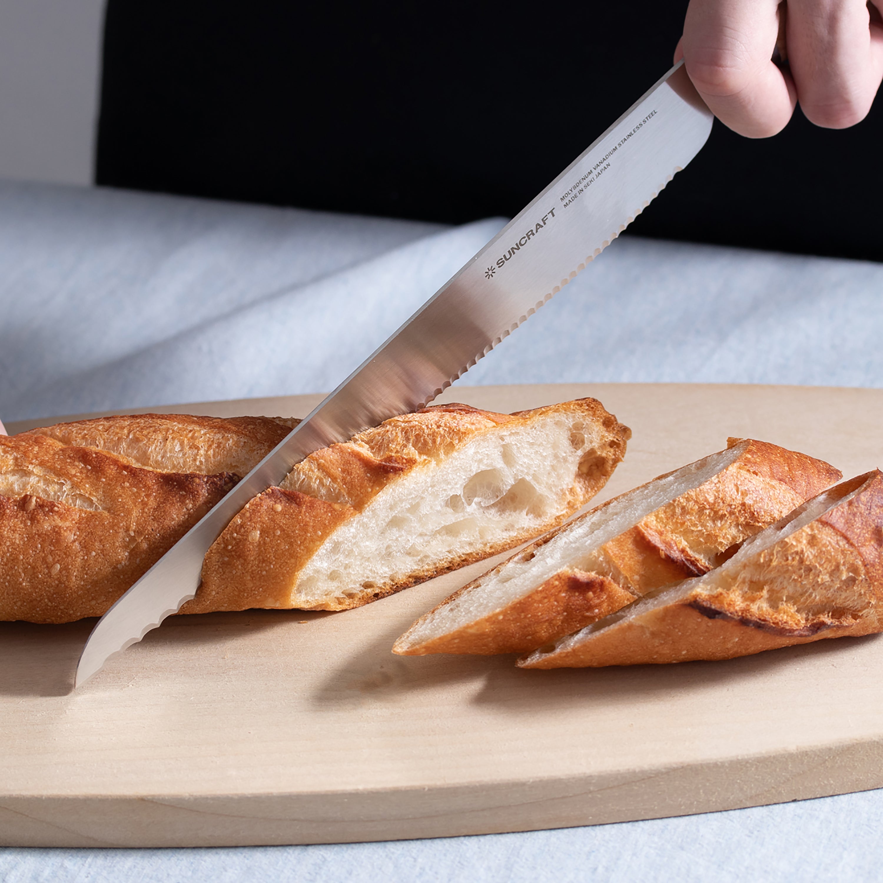 Close-up of Suncraft Seseragi bread knife showcasing serrated blade for left-handed users.