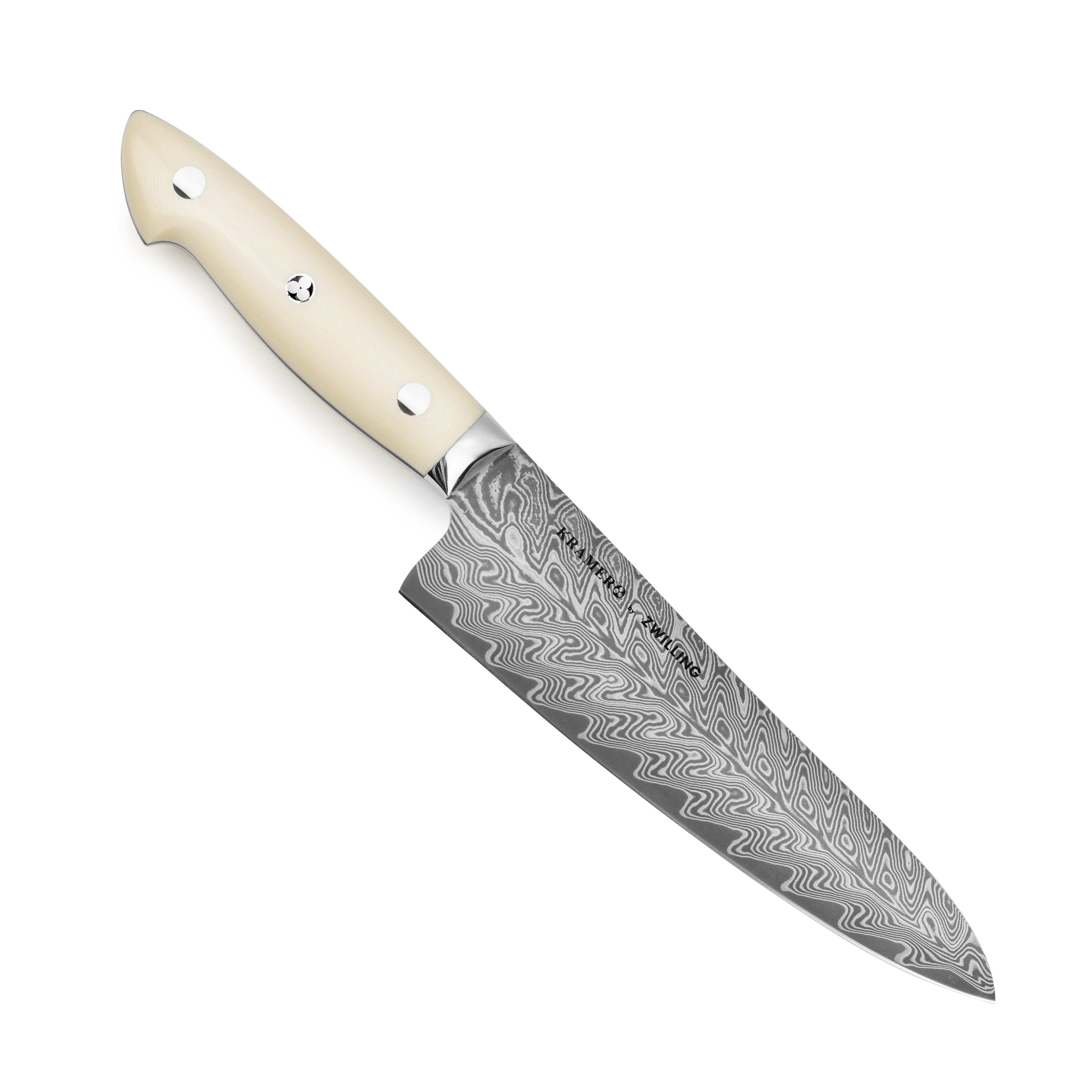 Kramer Cumulus Santoku Knife in action, slicing fresh vegetables on a wooden cutting board.