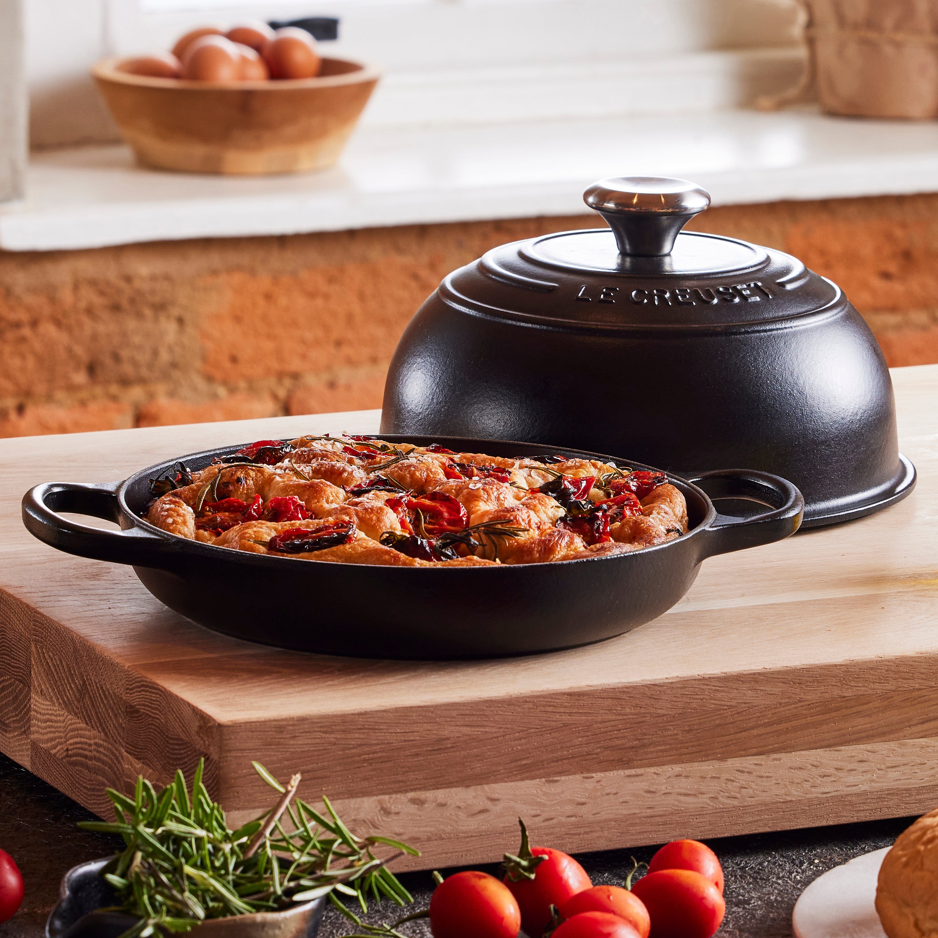Bread baking inside the Le Creuset cast iron oven, emphasizing even heat distribution and crust formation
