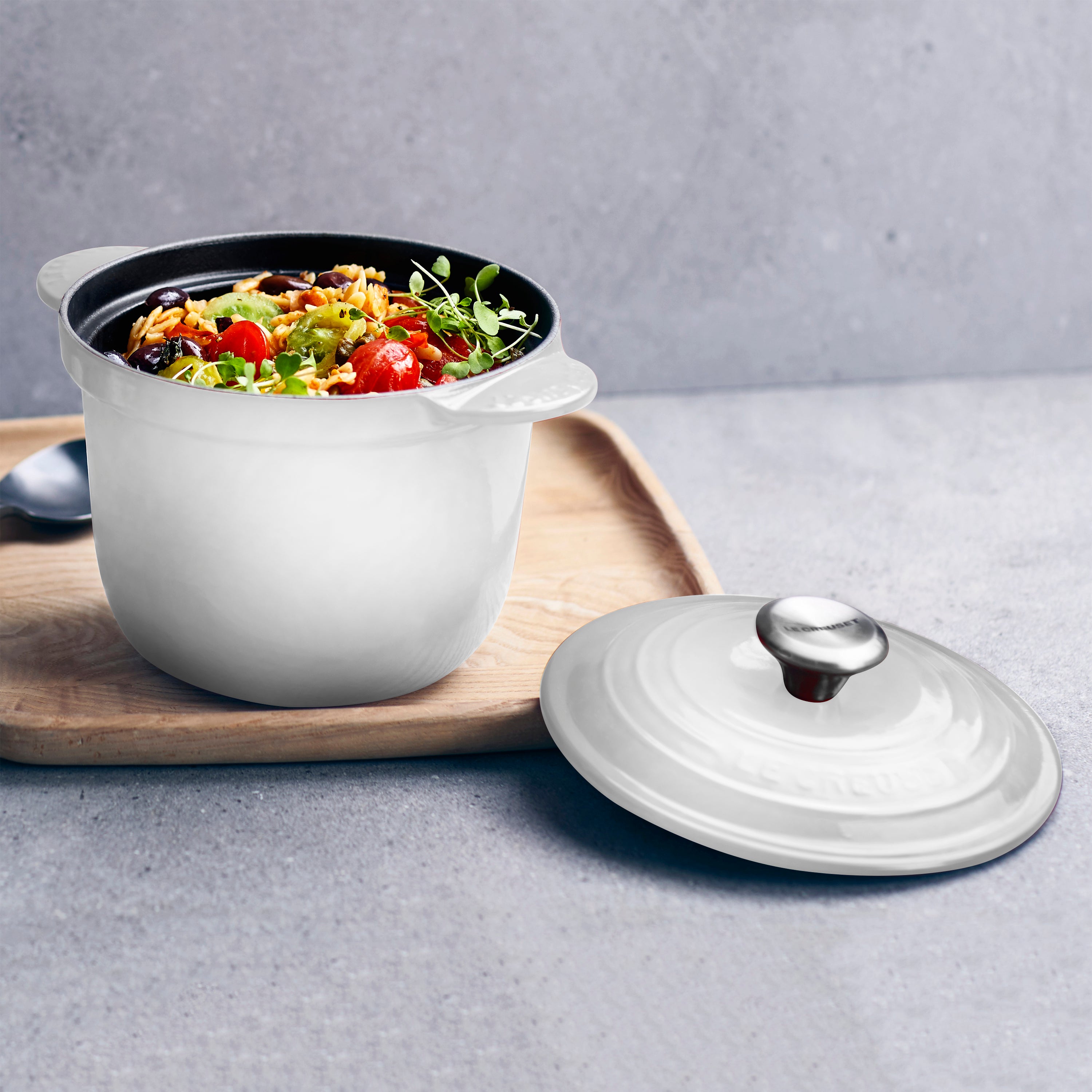 Le Creuset rice pot in action on a kitchen stove, demonstrating its compatibility with various cooktops.