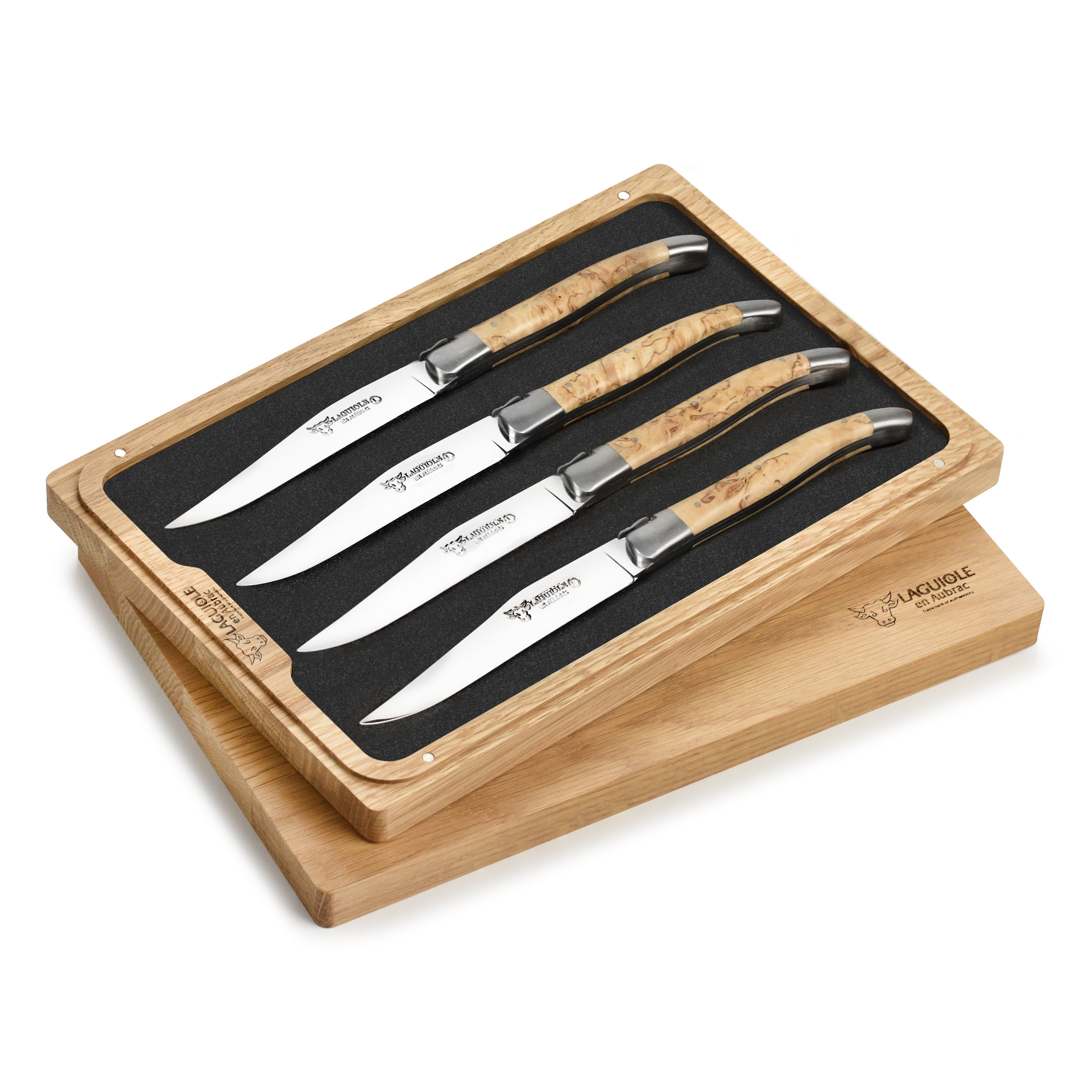 Laguiole en Aubrac steak knives set with birchwood handles on a dining table.