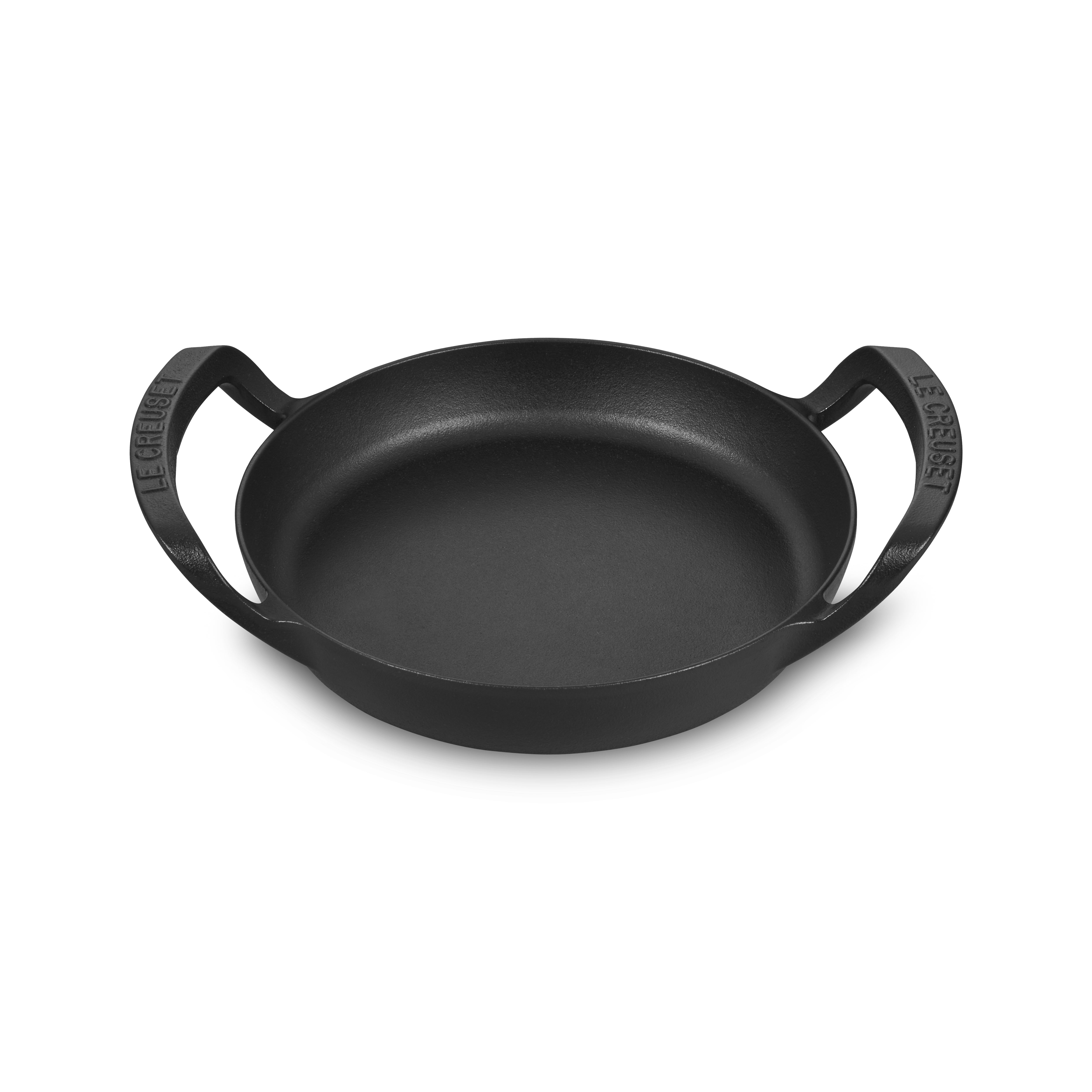 Top-down view of the Le Creuset Alpine cast iron skillet showing matte black enamel and spacious cooking surface — perfect outdoor cookware for grilling