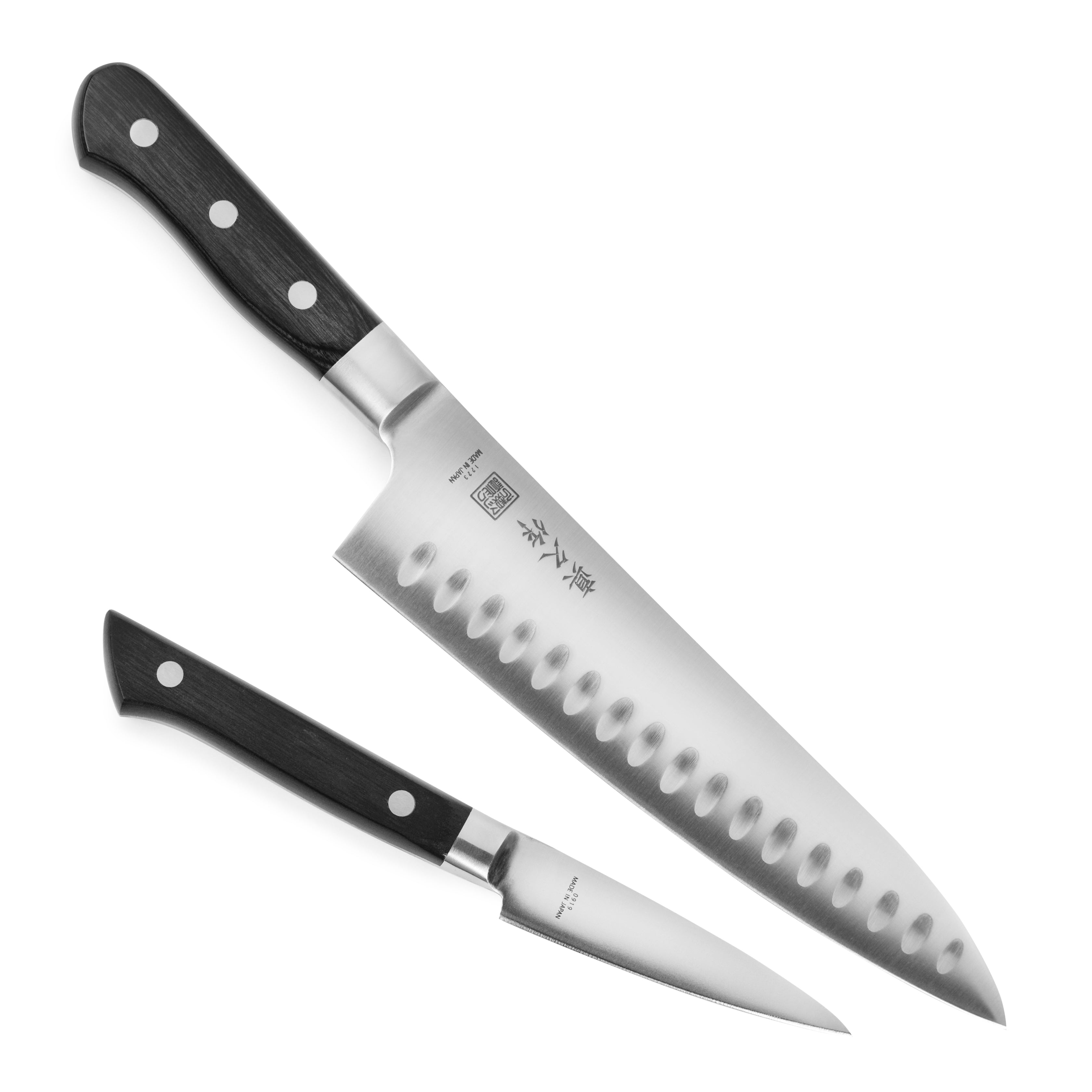 Close-up of MAC Japanese chef knife with hollow edge blade slicing vegetables