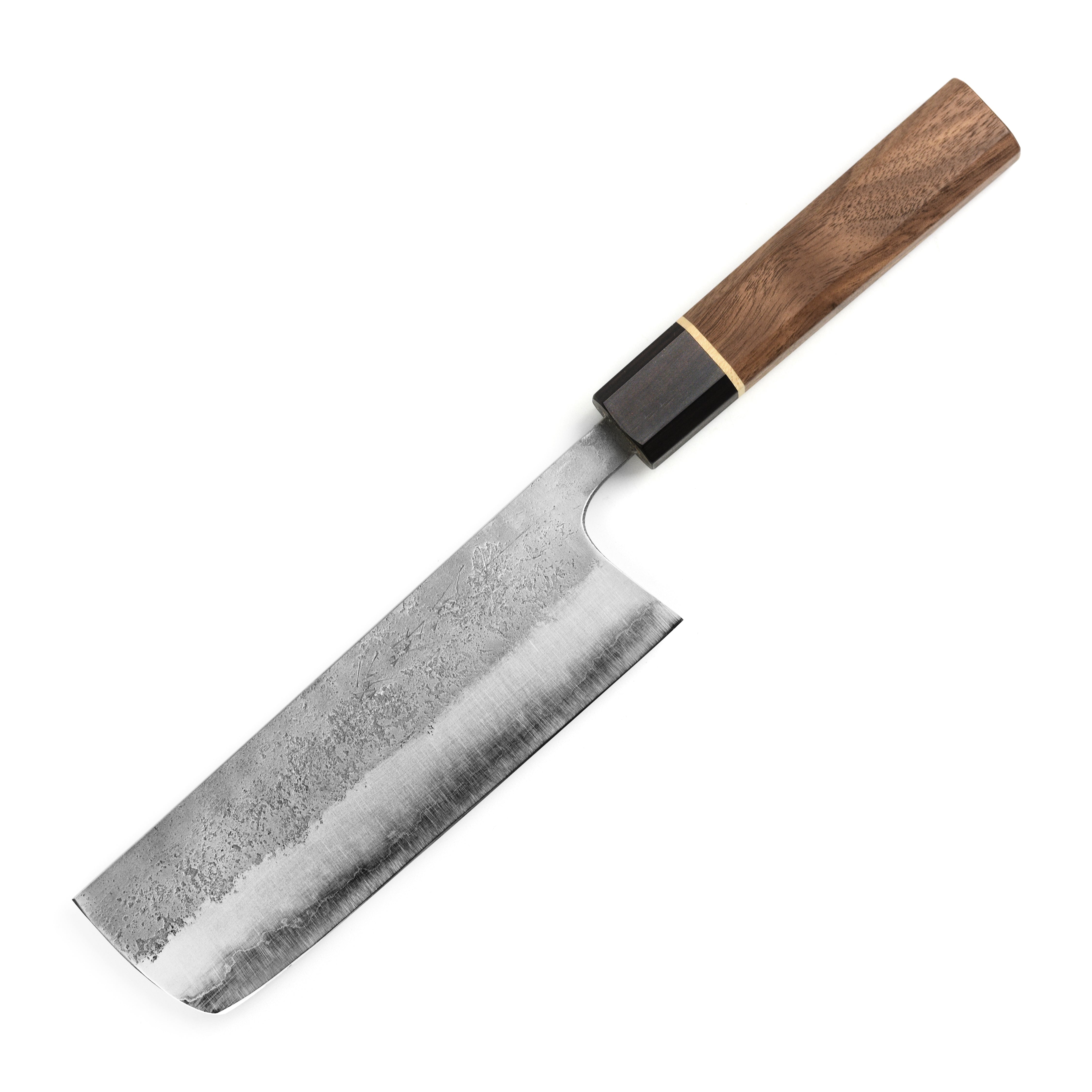 Close-up of the Aogami Nakiri knife demonstrating precision cuts on fresh vegetables.