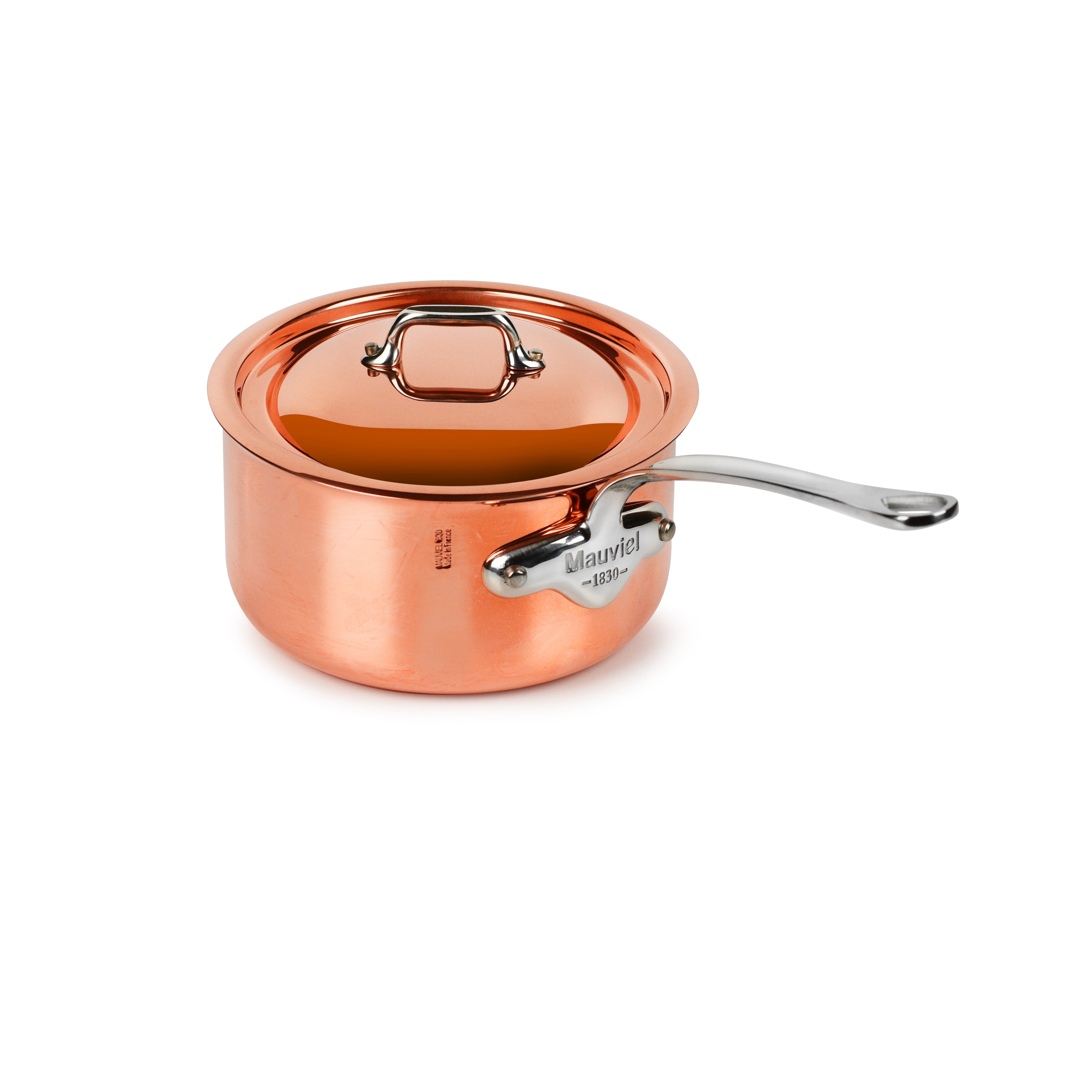 Close-up of Mauviel M'6S copper saucepan on induction stovetop showing layered construction and sturdy handle