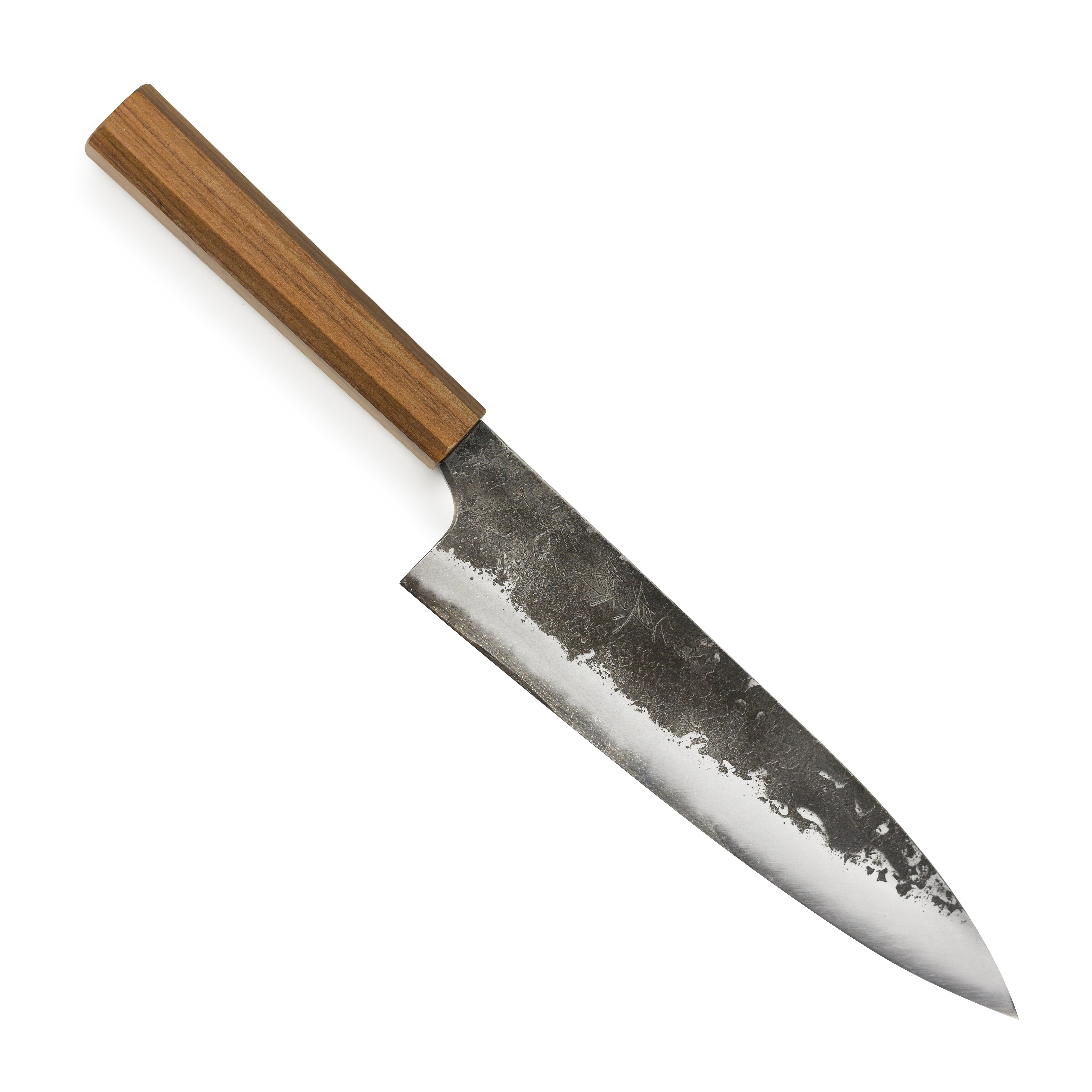 Mazaki Shirogami Kurouchi Gyuto knife in action, slicing through fresh vegetables with ease.