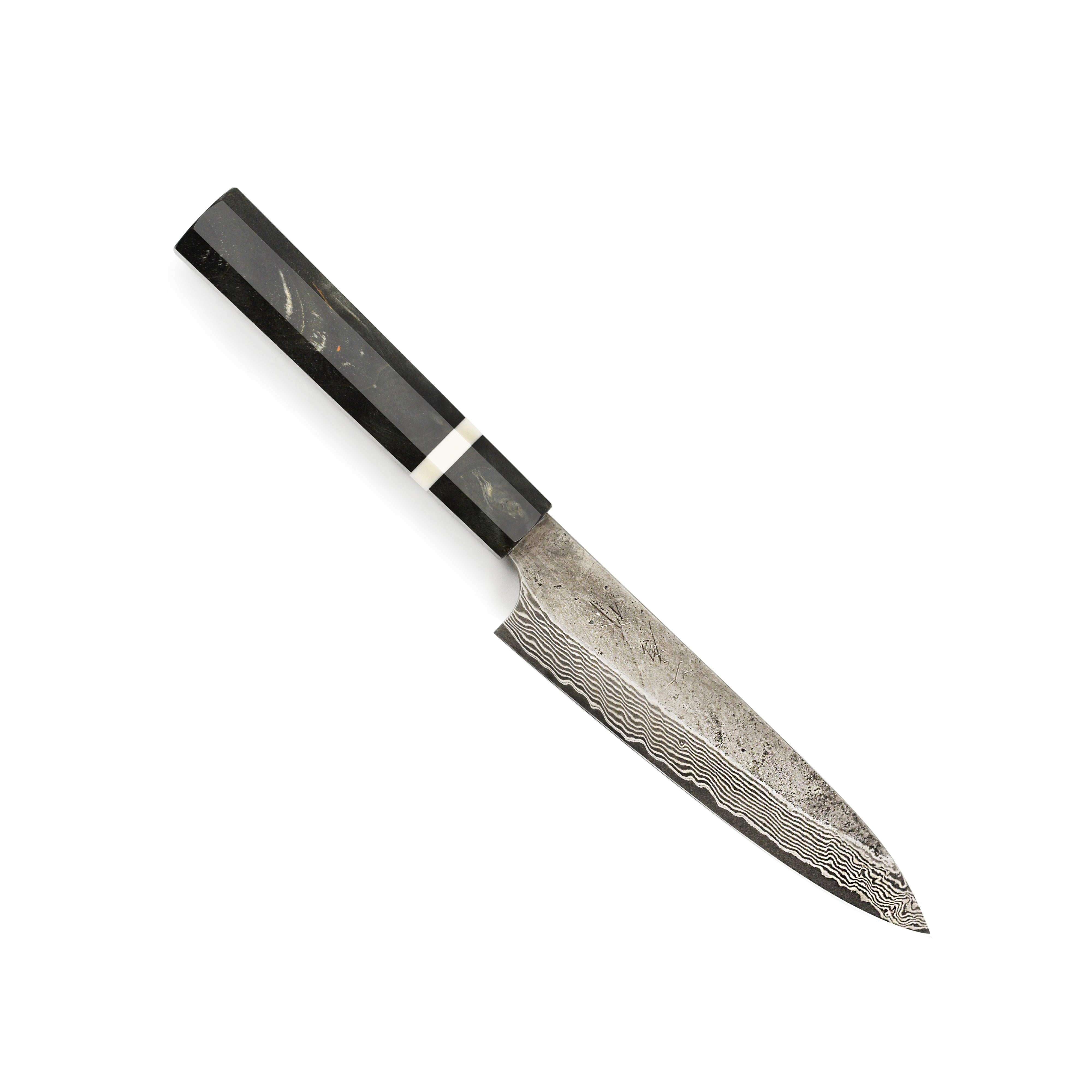 The Premium Nigara Ginsan Damascus Petty Knife in action, slicing fresh vegetables on a wooden cutting board.