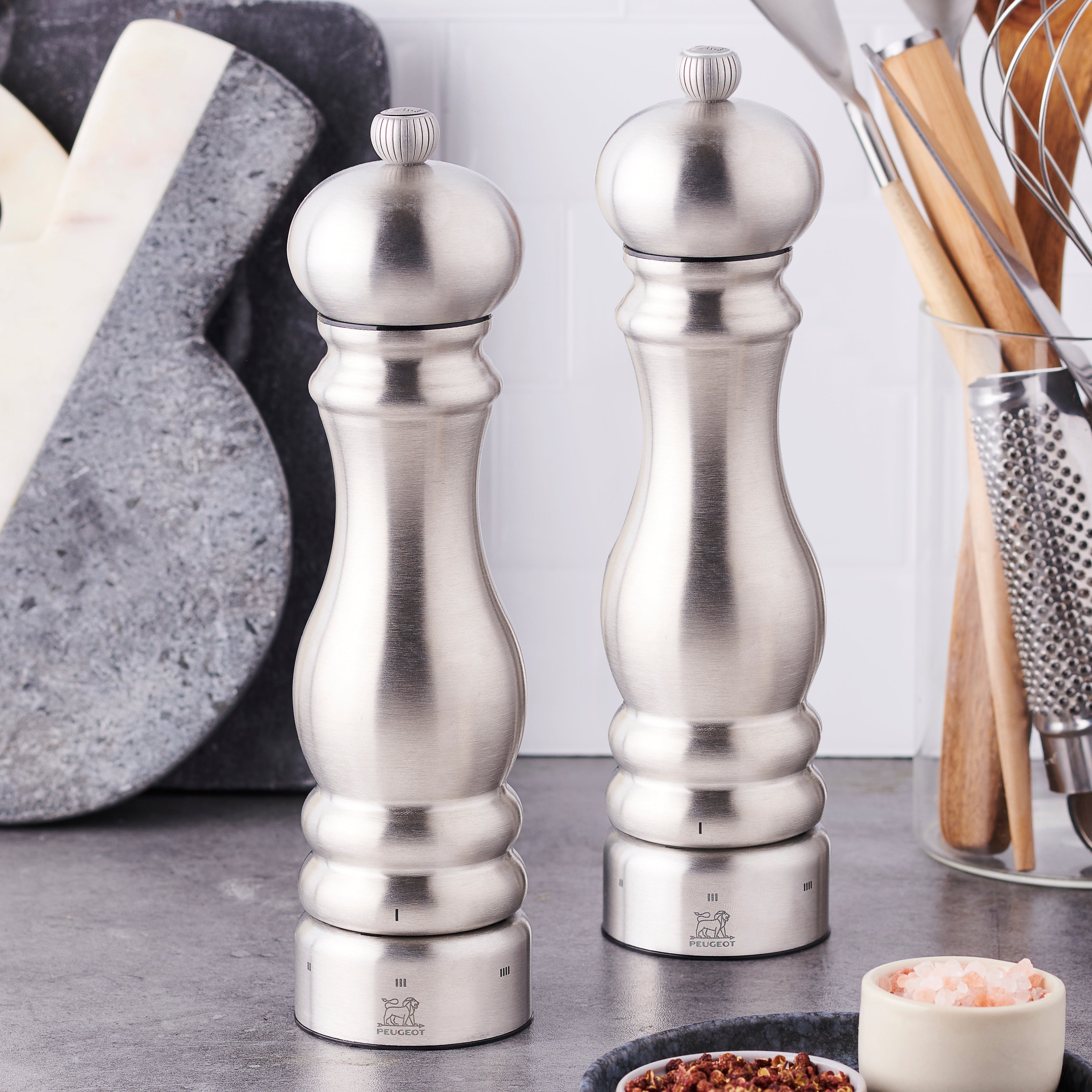 Peugeot Paris stainless steel salt and pepper mill set on kitchen counter, showing modern design and adjustable grind feature