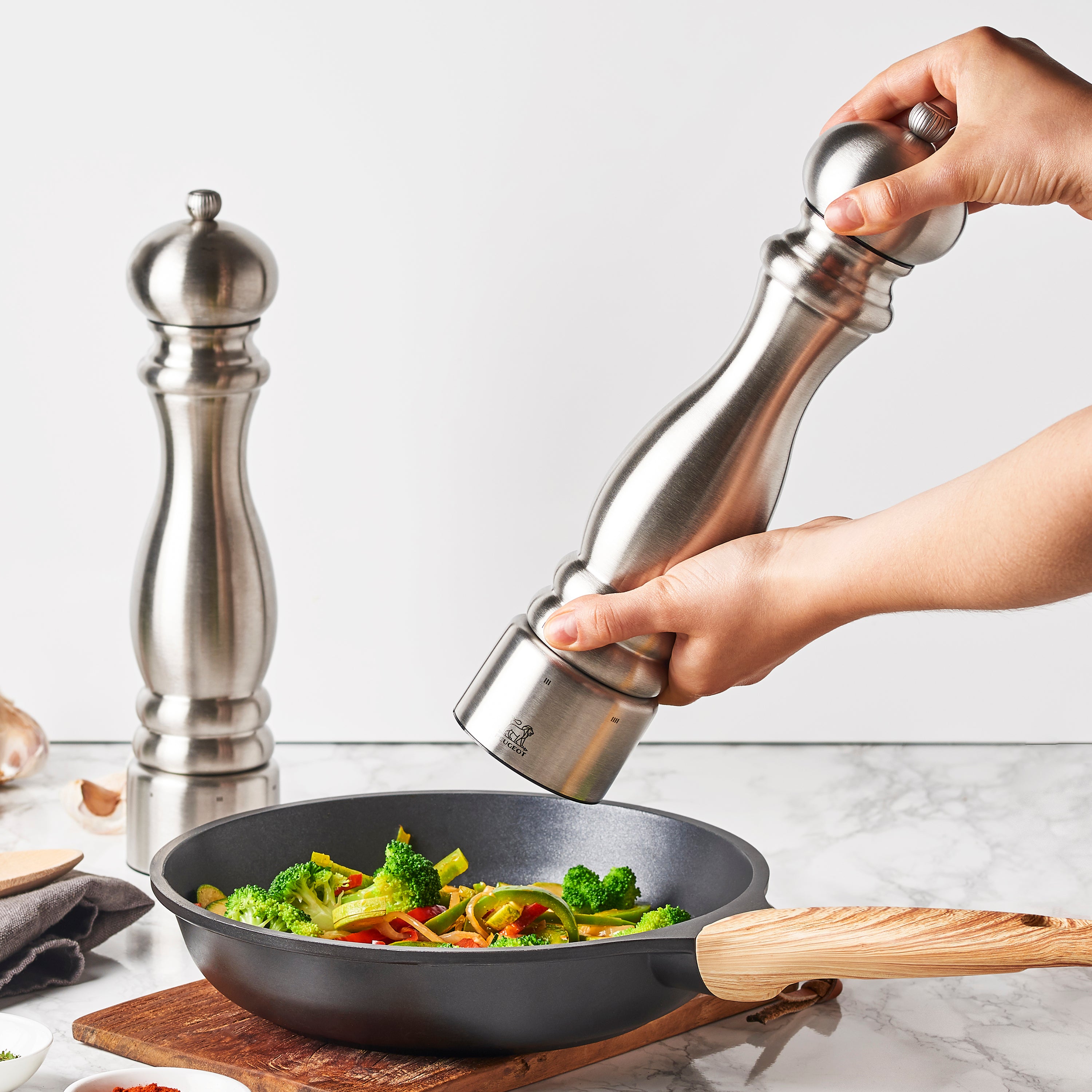 Elegant Peugeot salt and pepper mill set on a dining table, enhancing the dining experience.