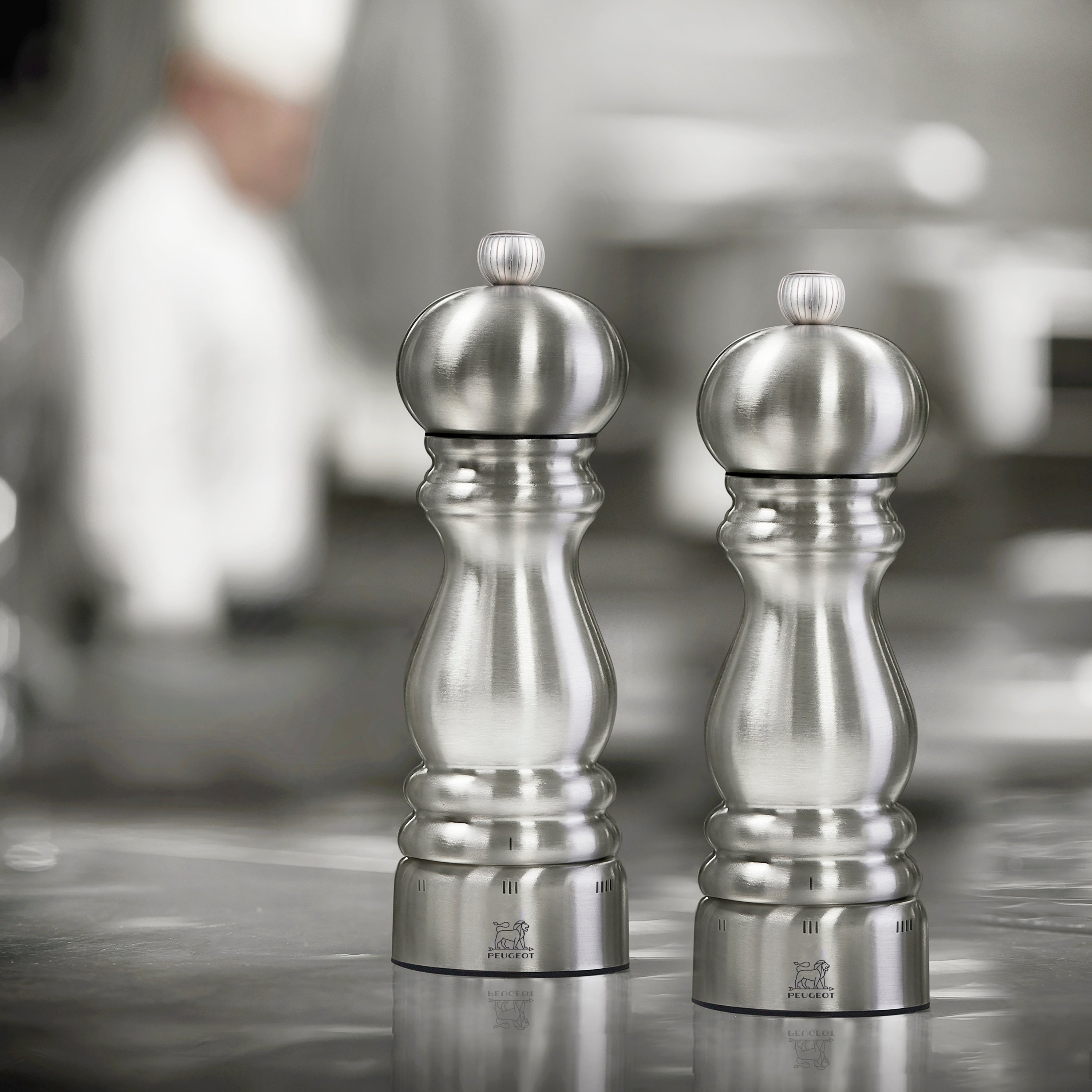Elegant Peugeot Paris salt and pepper grinder set displayed on a kitchen counter.
