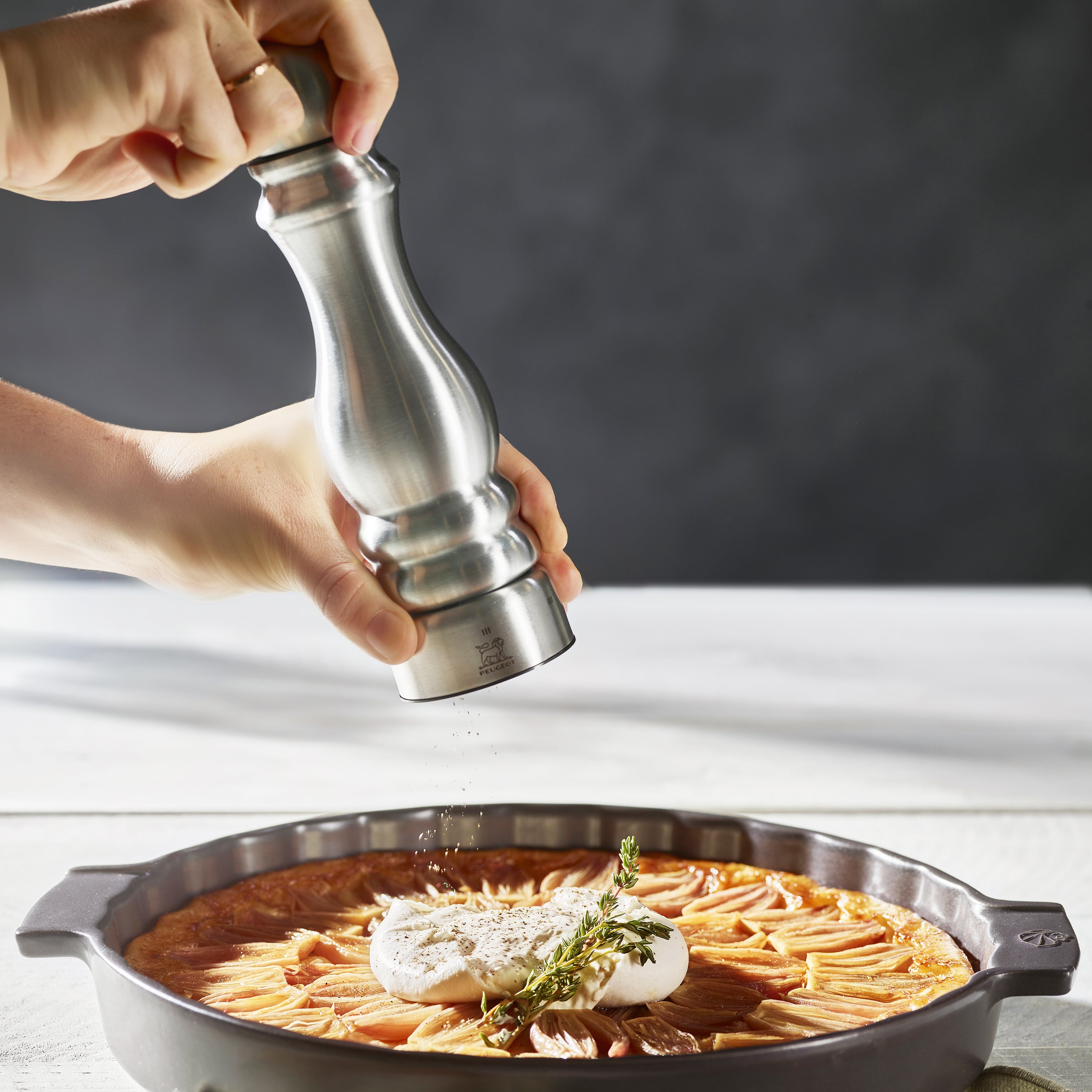 Elegant Peugeot Paris salt and pepper grinder set displayed on a kitchen counter.