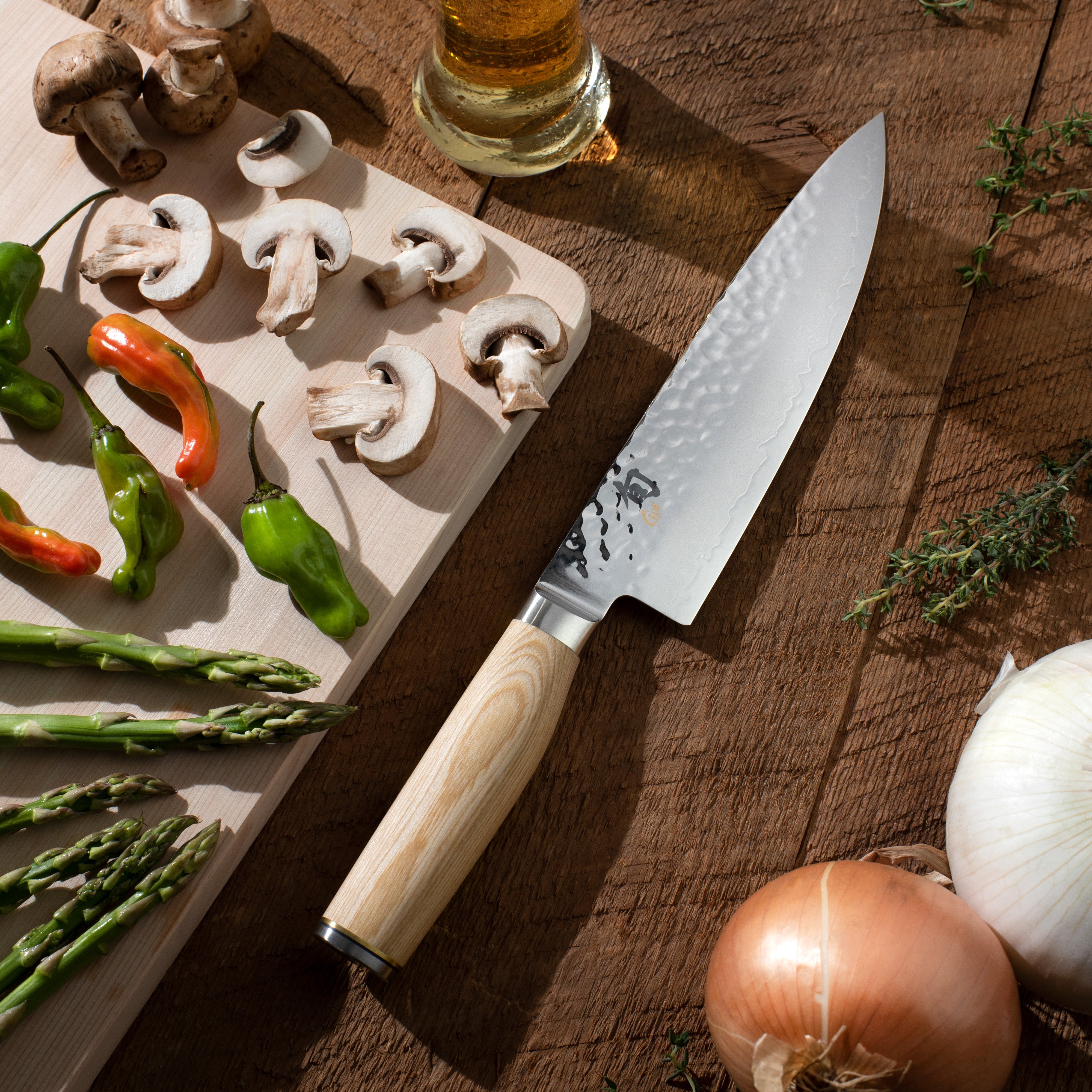 Shun Premier Blonde 8-Inch Chef Knife with a sleek blade design on a wooden cutting board.