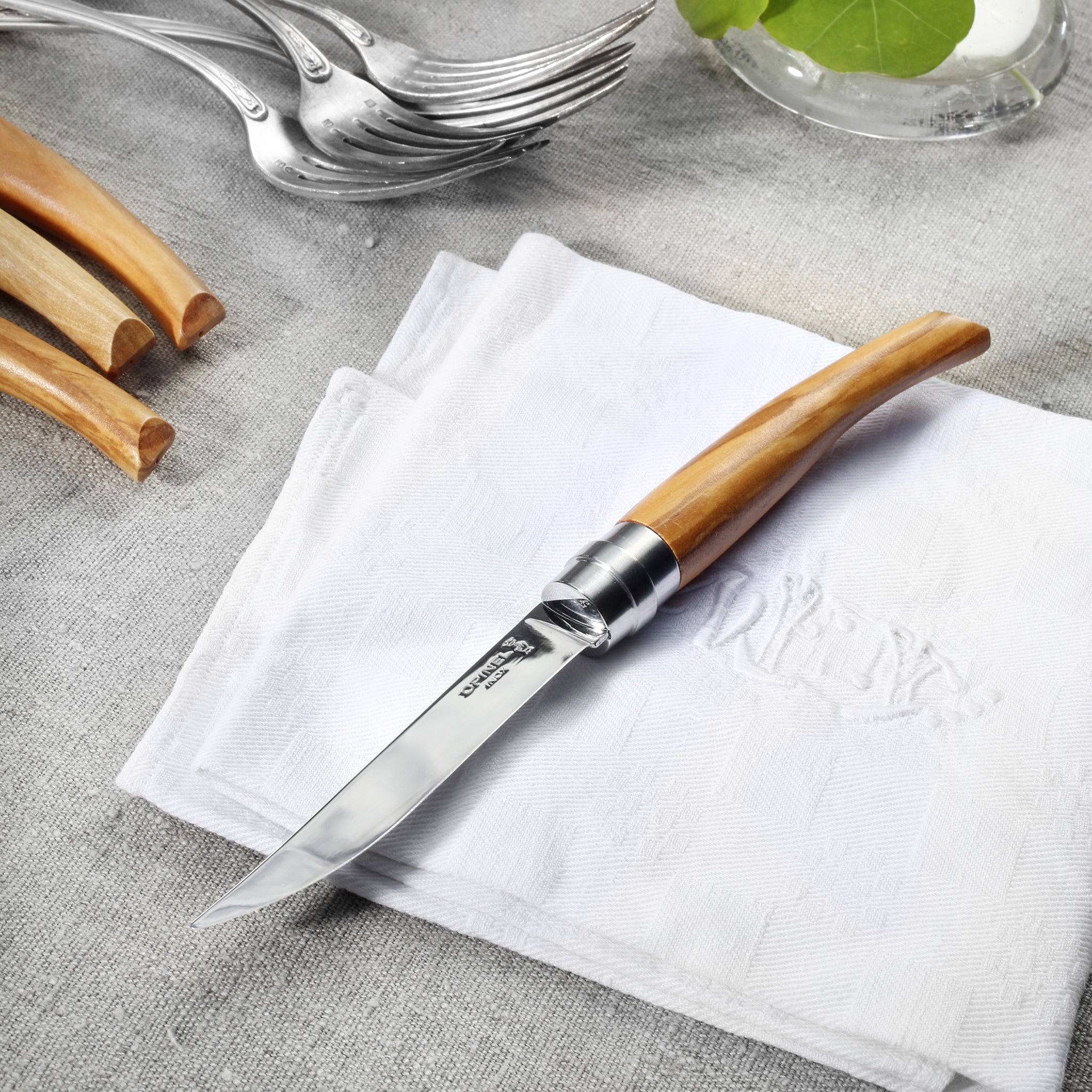 Olivewood steak knives arranged elegantly on a dining table ready for a meal.