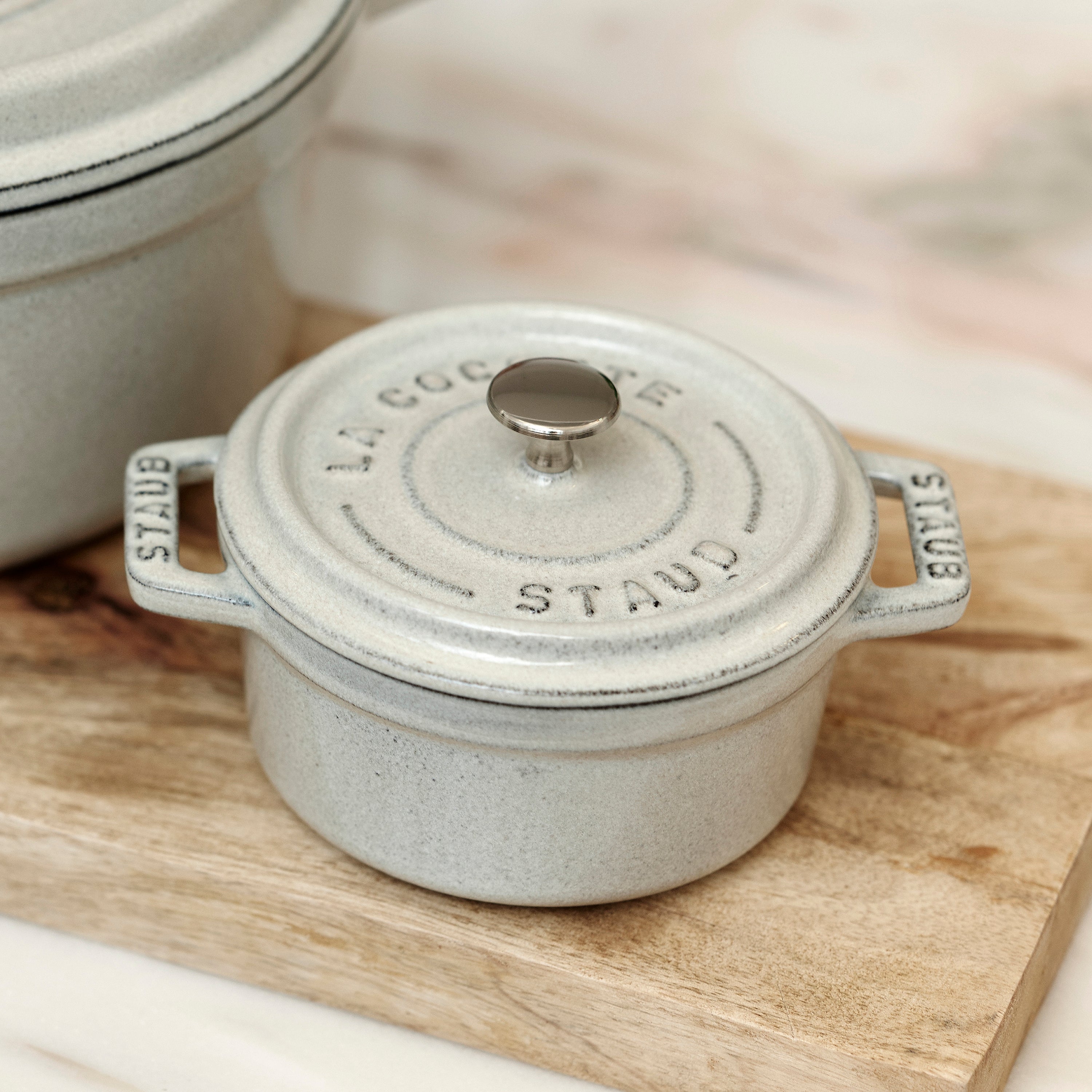 Close-up of the White Truffle Mini Round Enameled Dutch Oven showcasing its textured interior and lid.
