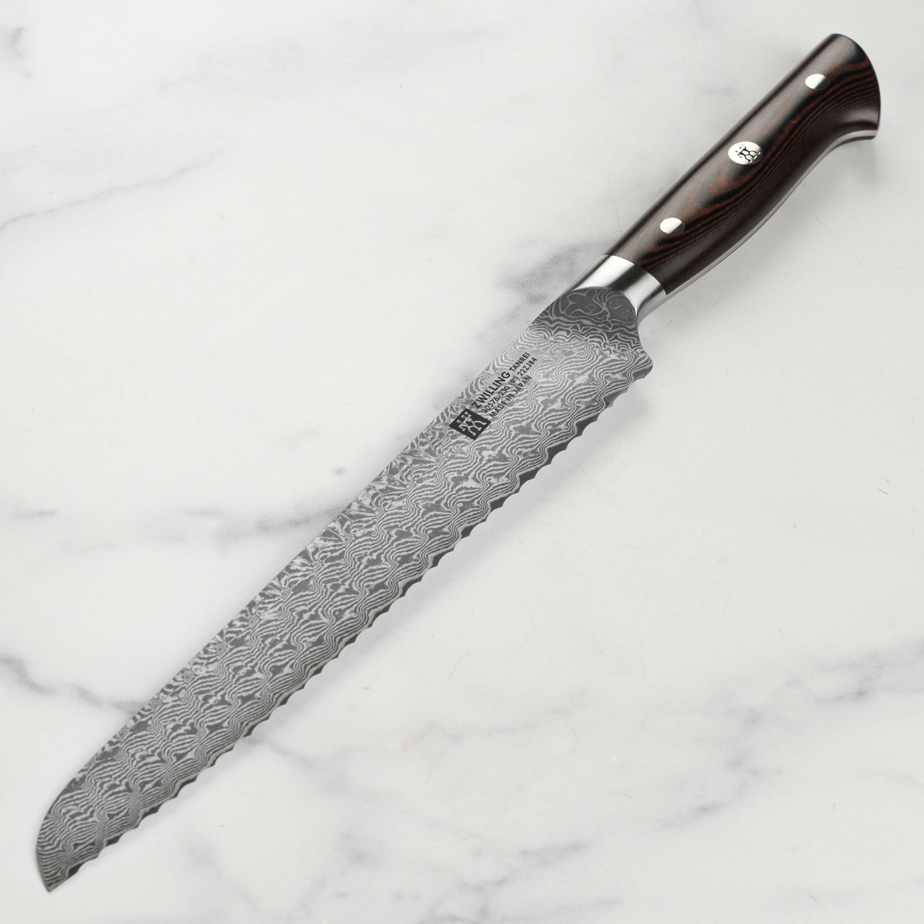 Close-up of the Zwilling Tanrei 9-inch Damascus bread knife showcasing its sharp blade and elegant handle.