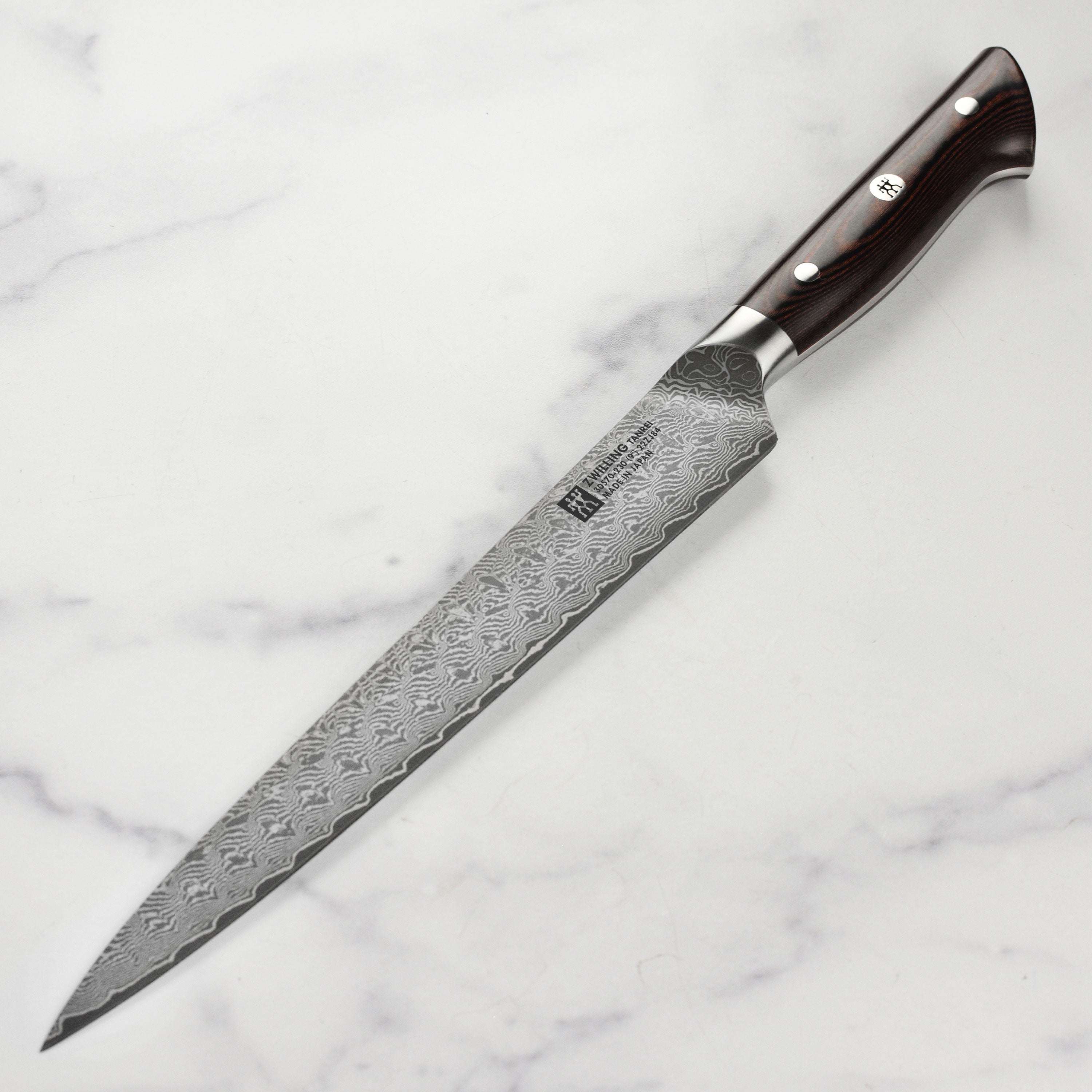 Close-up of the Zwilling Tanrei Damascus steel slicing knife blade showing intricate pattern