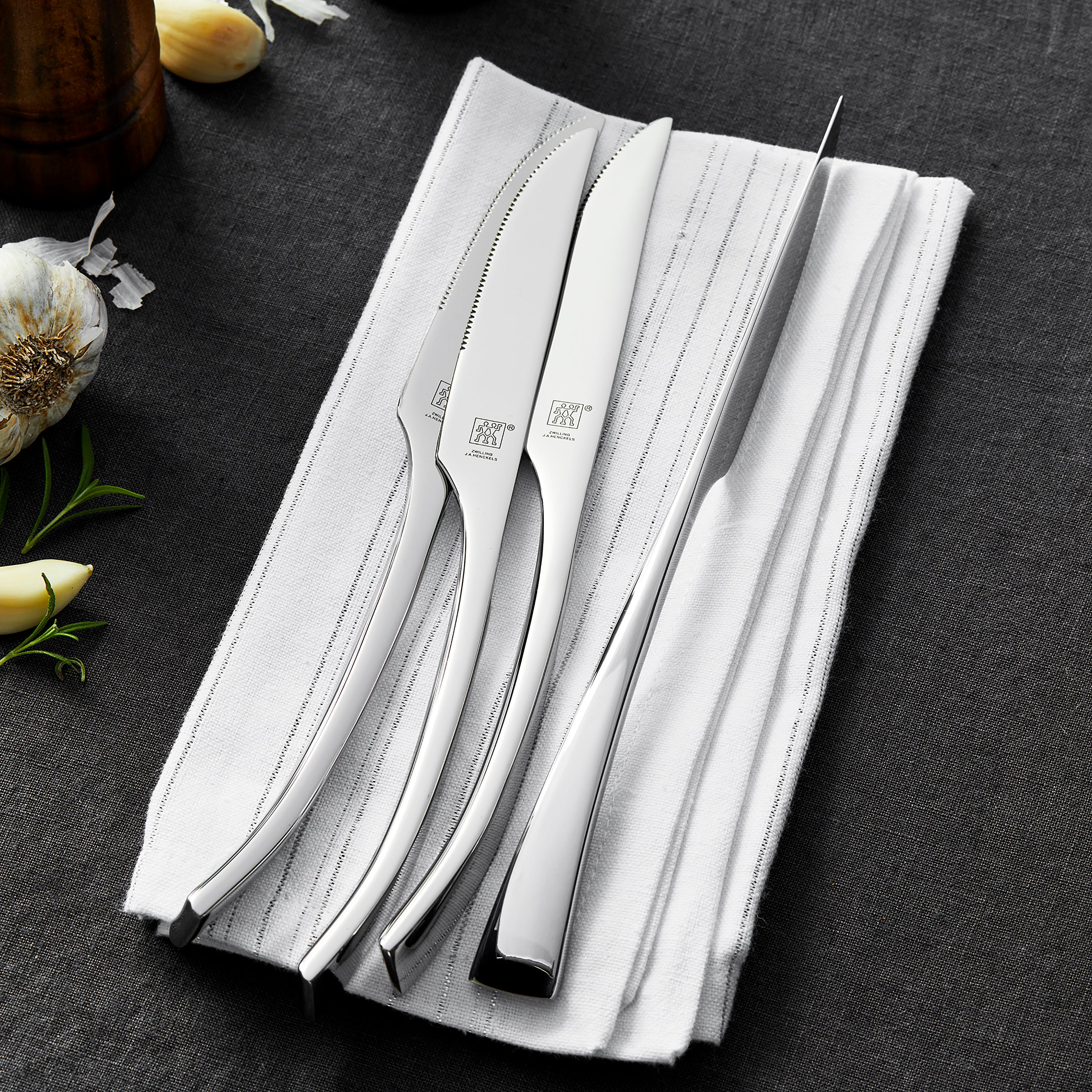 Set of stainless steel utensils arranged for a formal dinner setting