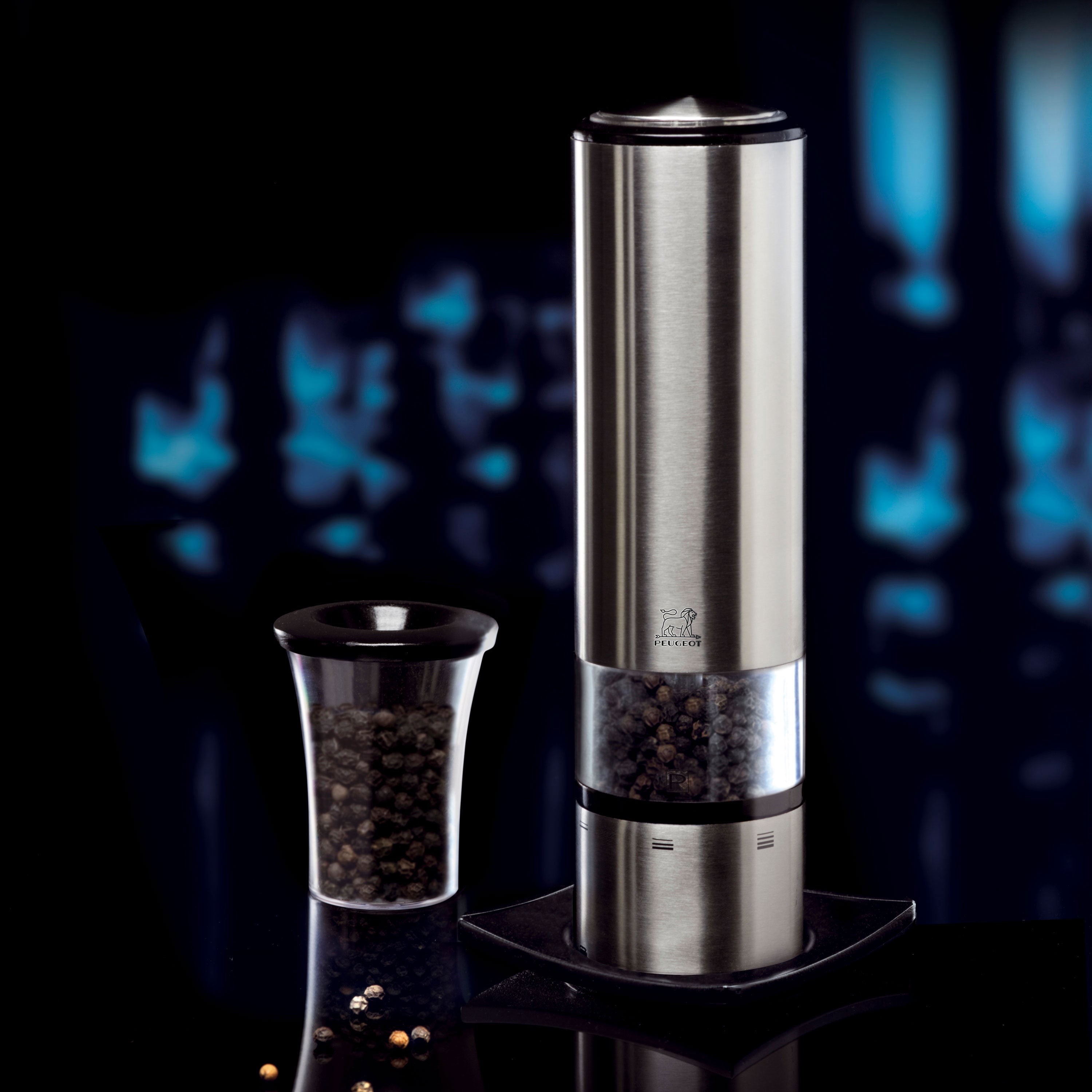 Peugeot Elis Sense electric pepper mill with LED light in action, grinding peppercorns.