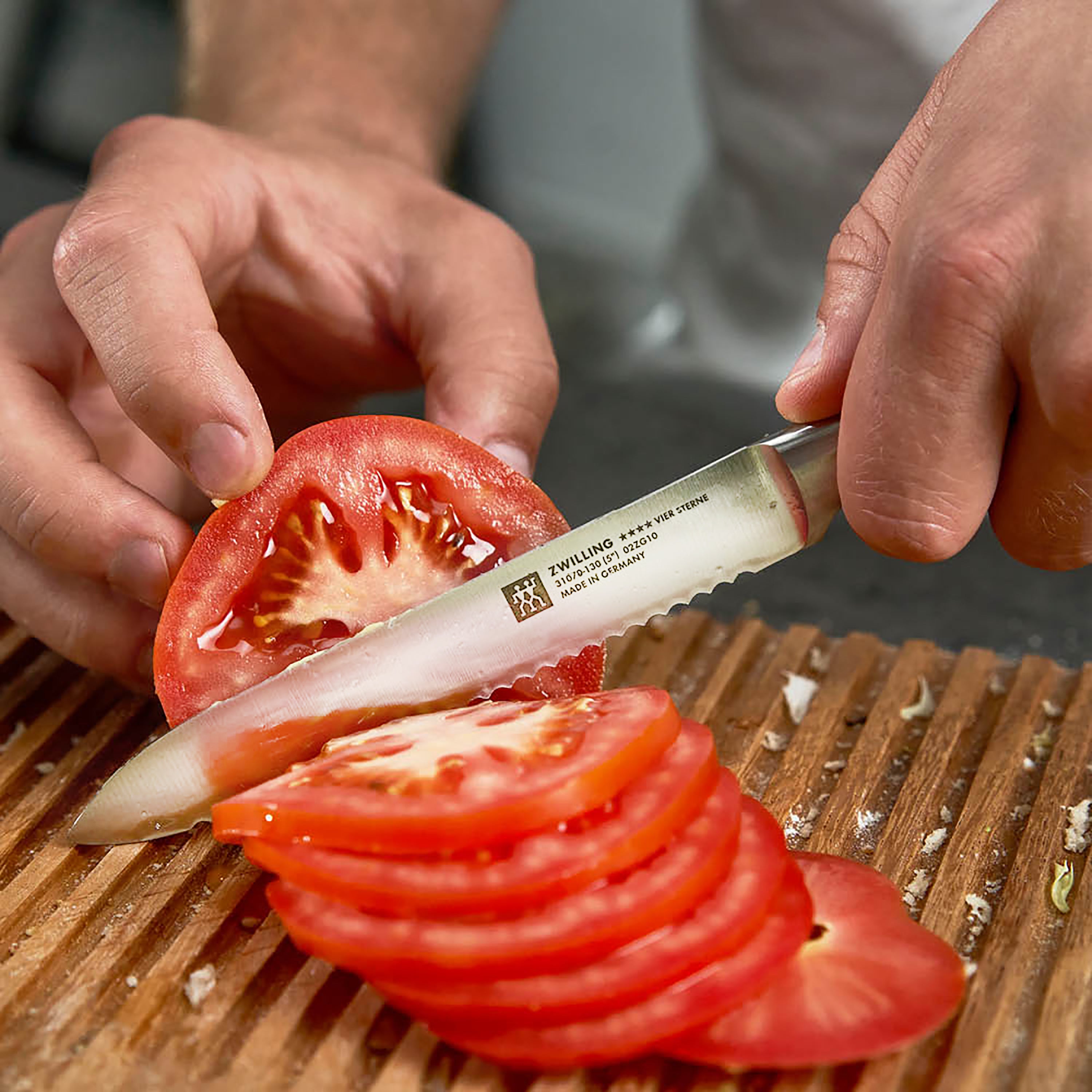 Top view of Zwilling Four Star 5" serrated utility knife showcasing the blade and handle design.