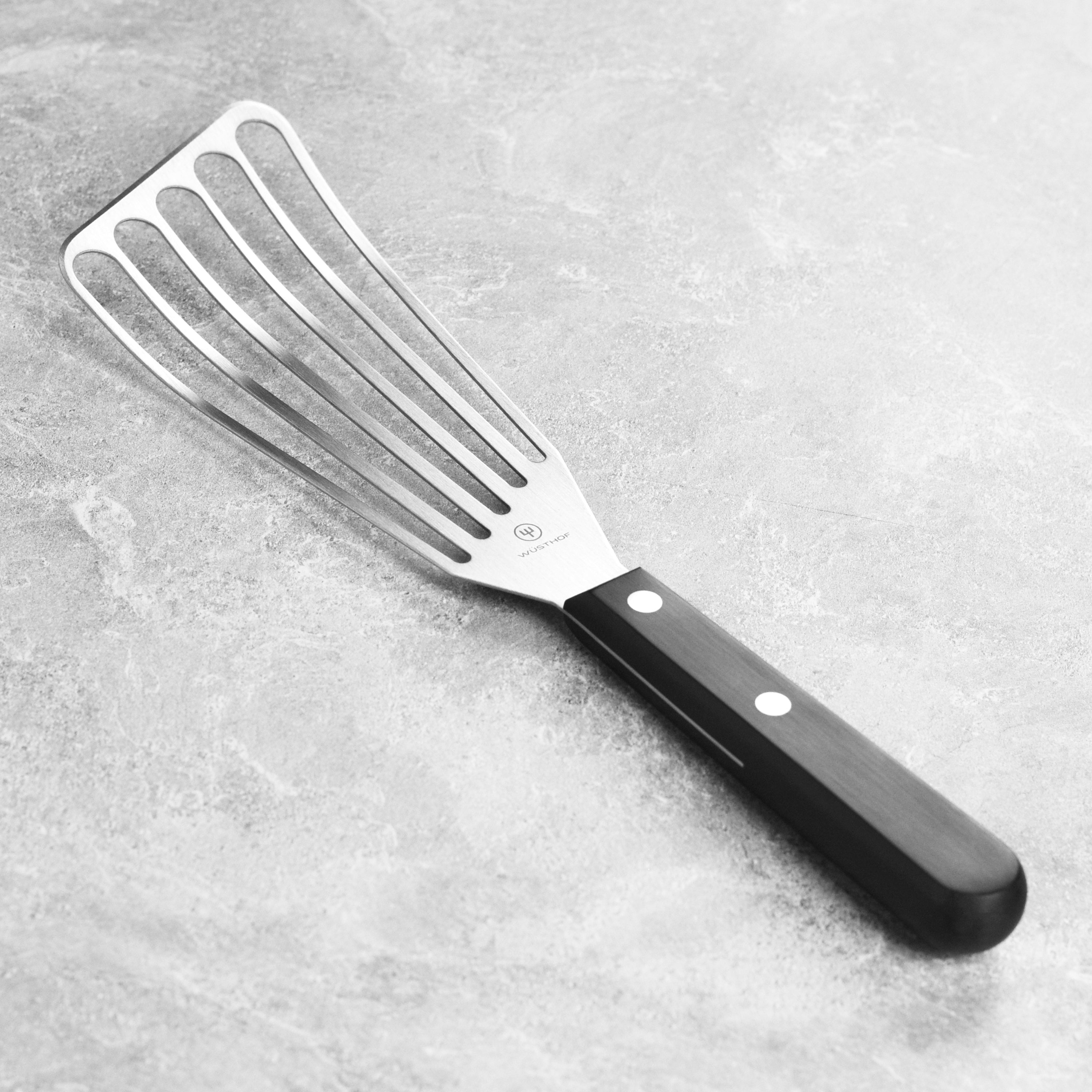 A close-up of the Wusthof slotted spatula showcasing its flexible blade and ergonomic handle.