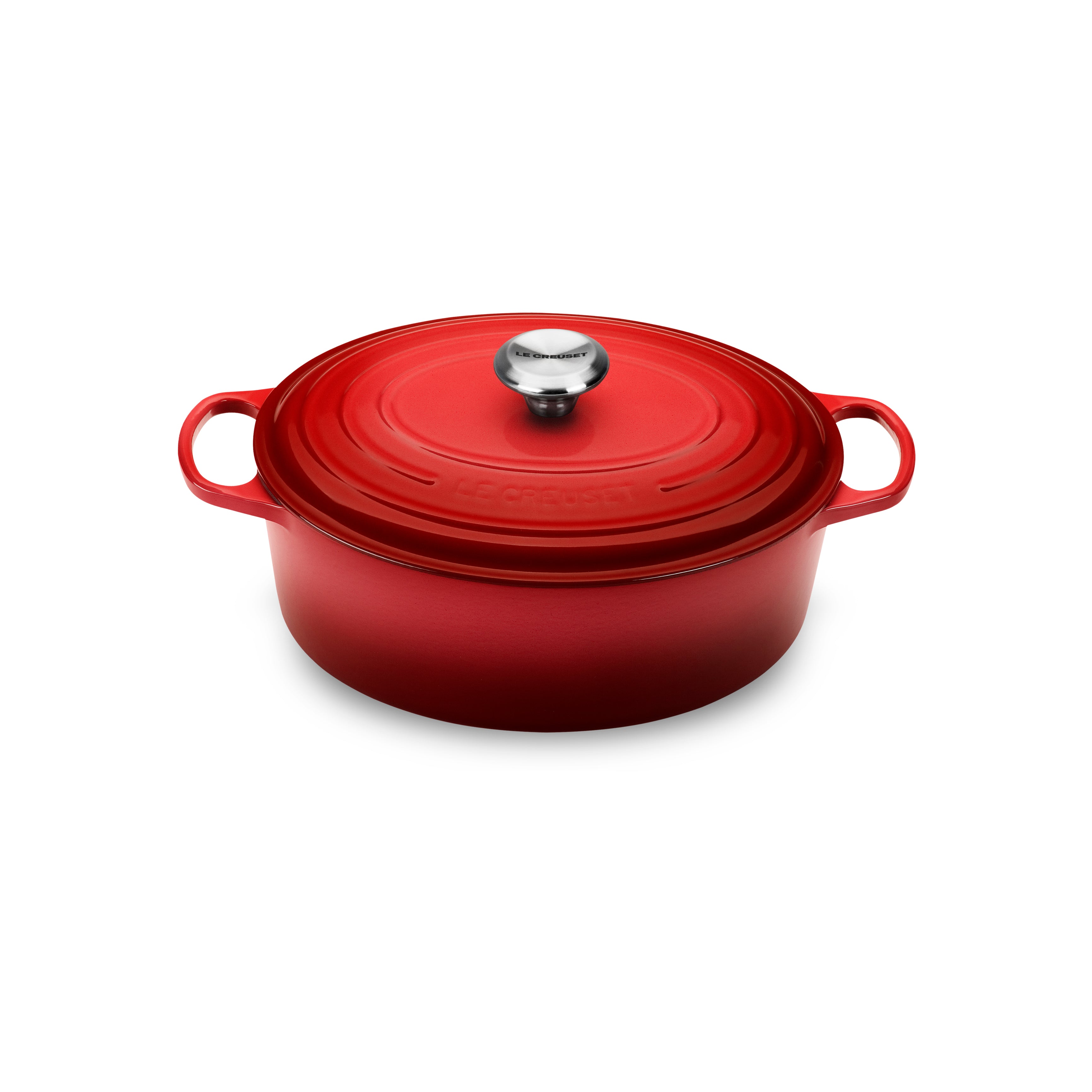 Le Creuset Cerise oval Dutch oven with lid on a stovetop, showing its vibrant color and cast iron construction