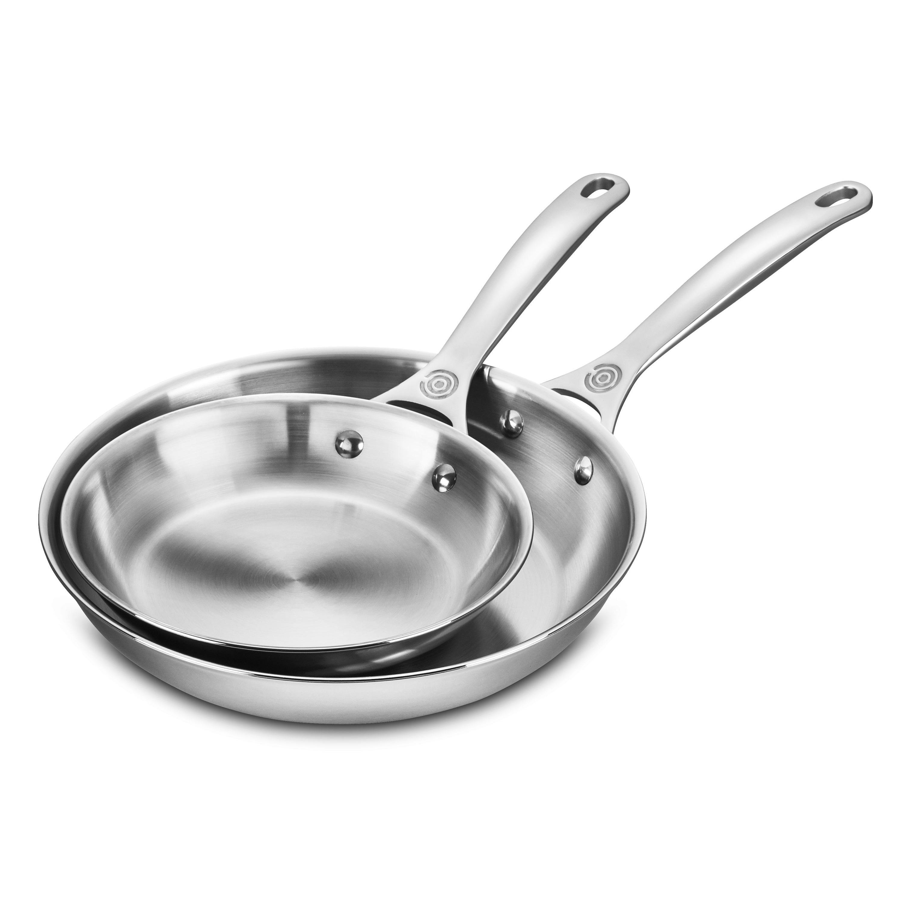 Top view of both stainless steel fry pans with Le Creuset branding, highlighting polished finish