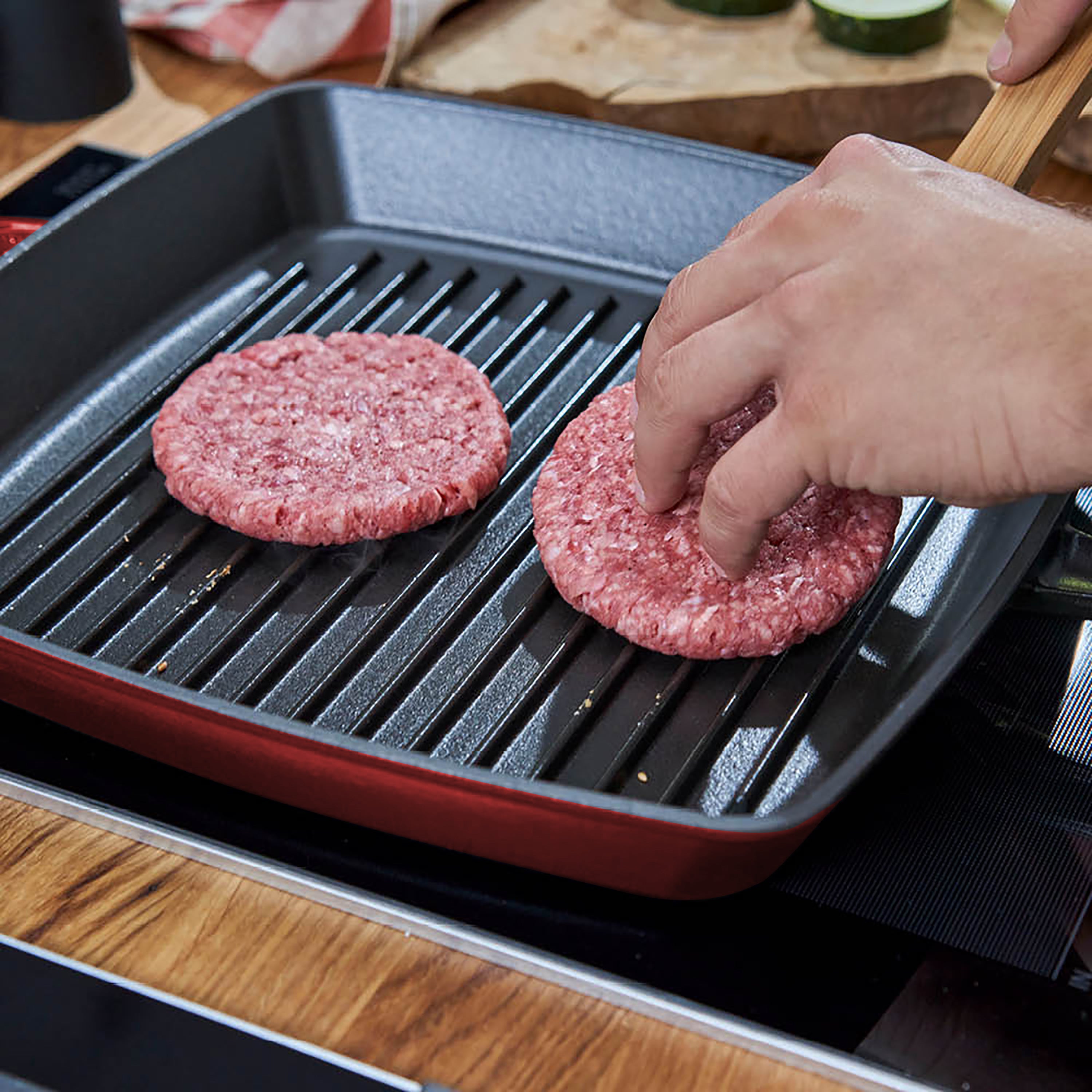 The Grenadine cast iron grill pan set on a rustic dining table, emphasizing its elegant design.