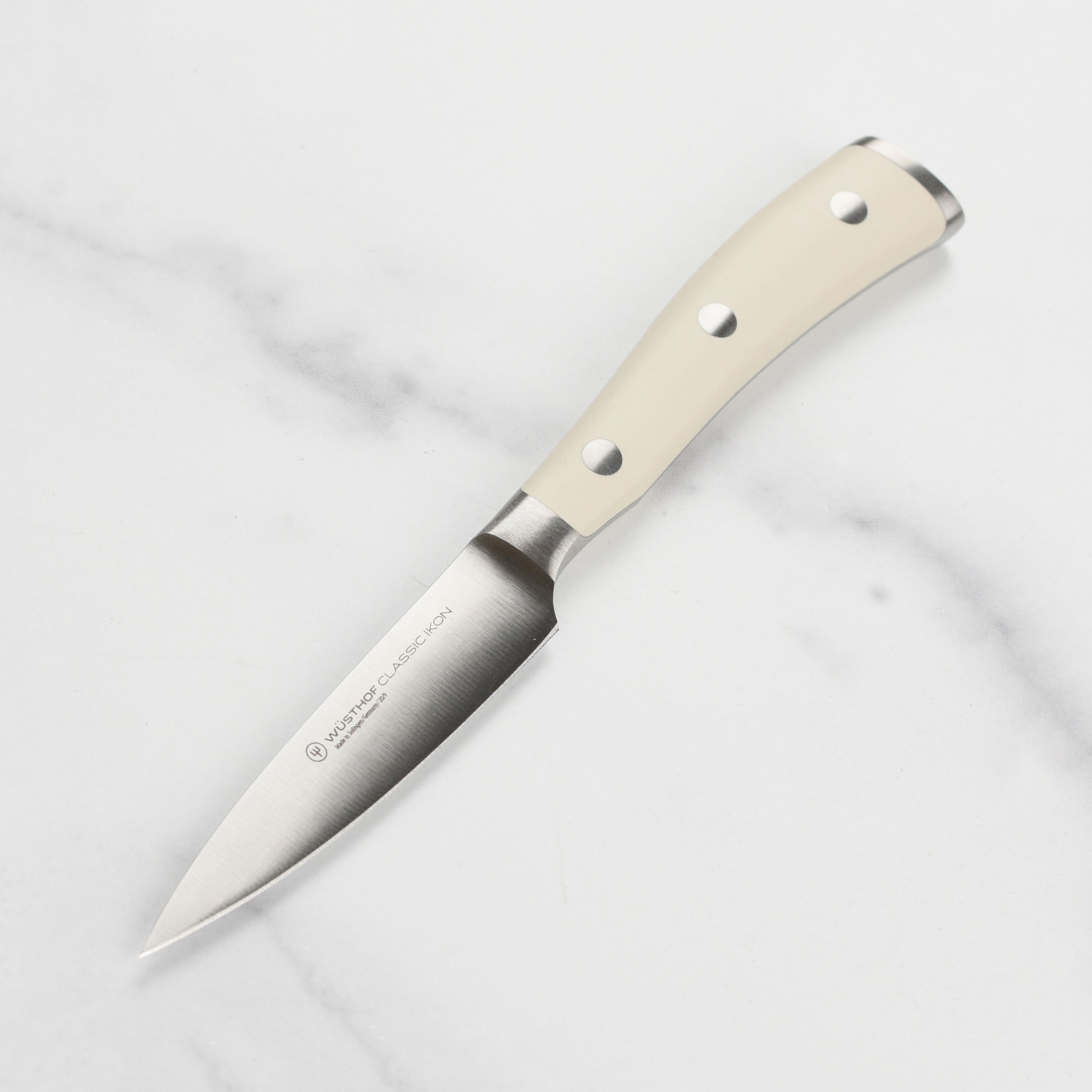 Wusthof Classic Ikon Cream Paring Knife showcasing its sharp blade and ergonomic handle.
