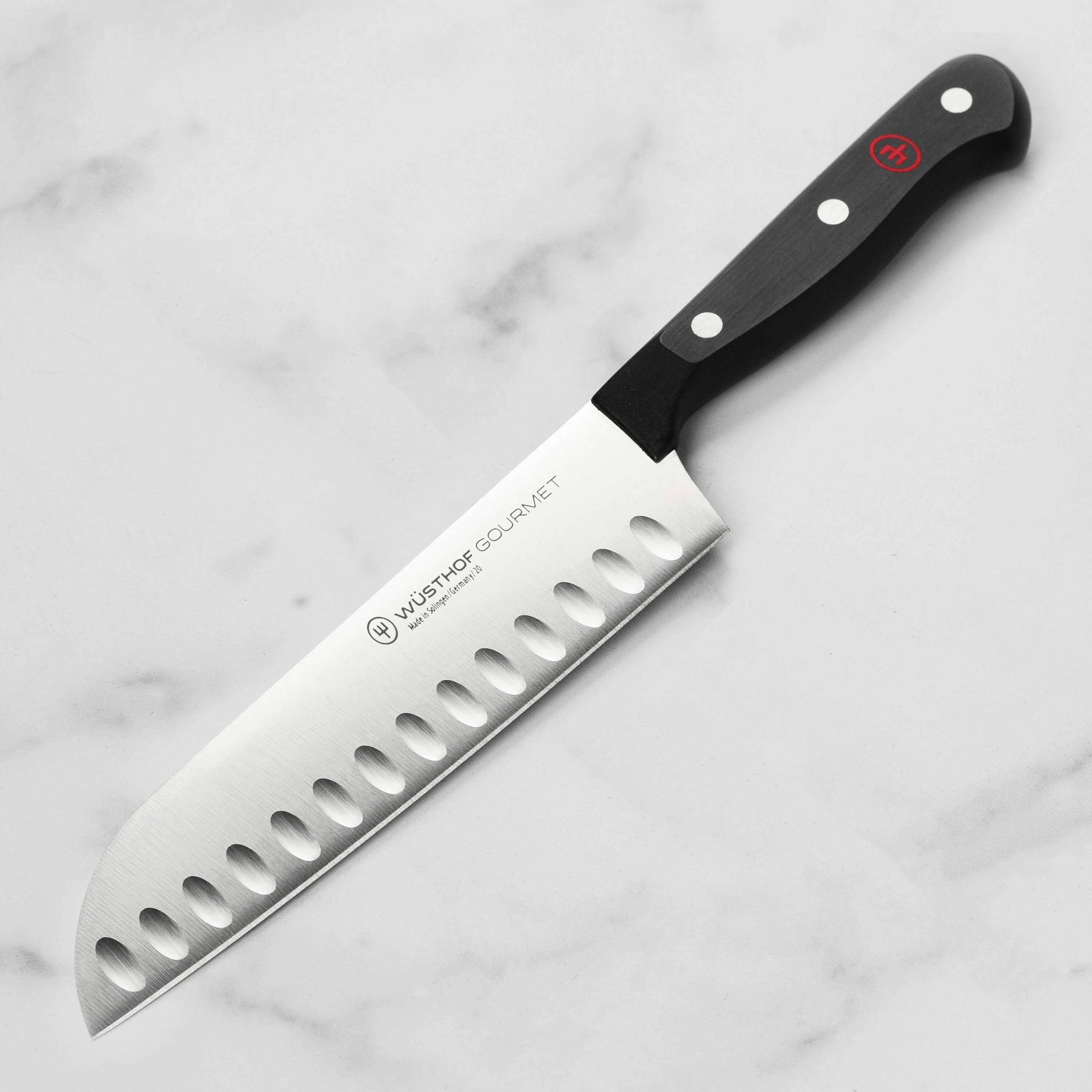 Wusthof Gourmet 7-inch hollow edge Santoku knife with a sharp blade and ergonomic handle for precise cuts