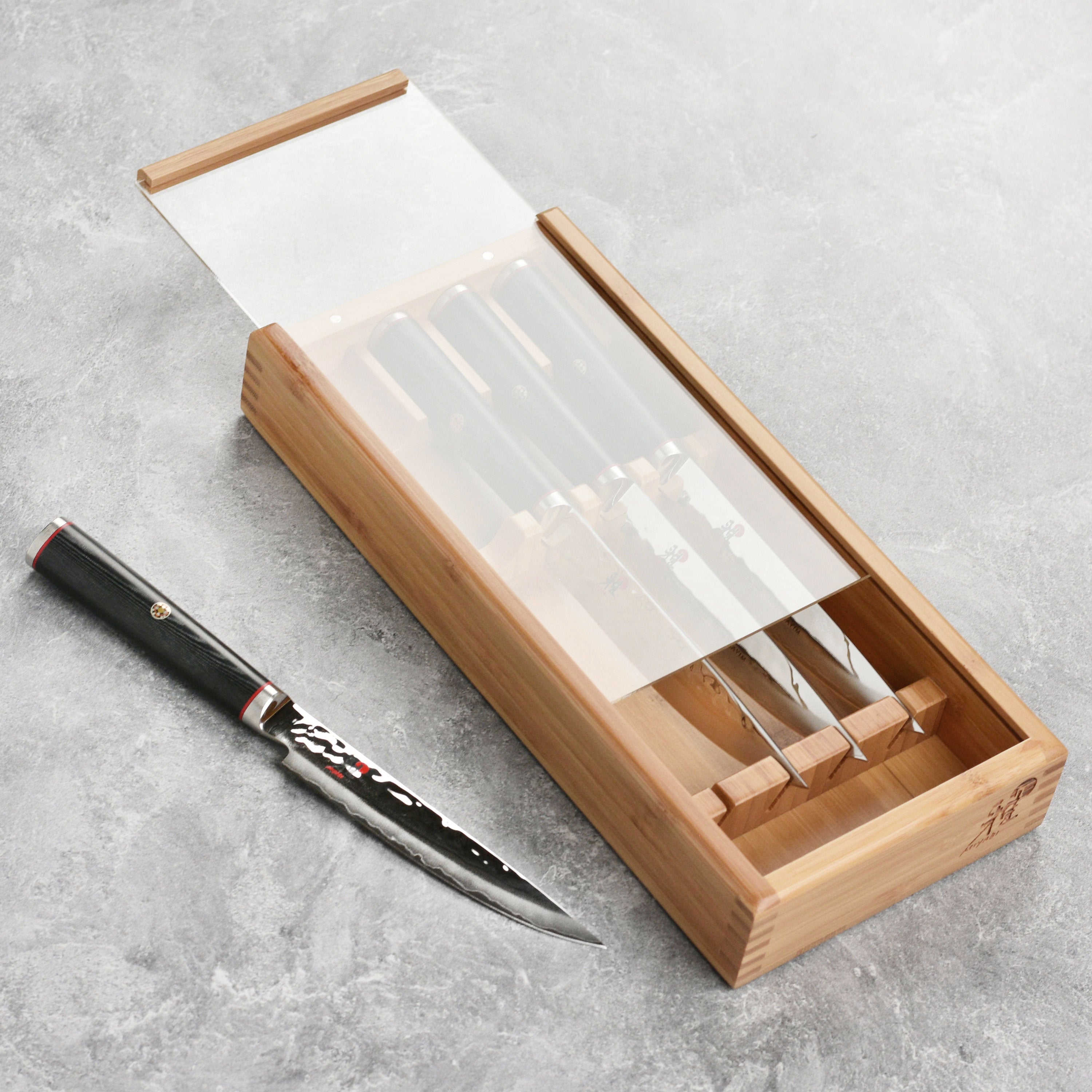 Miyabi Mizu SG2 Damascus steak knives with hammered finish on a cutting board