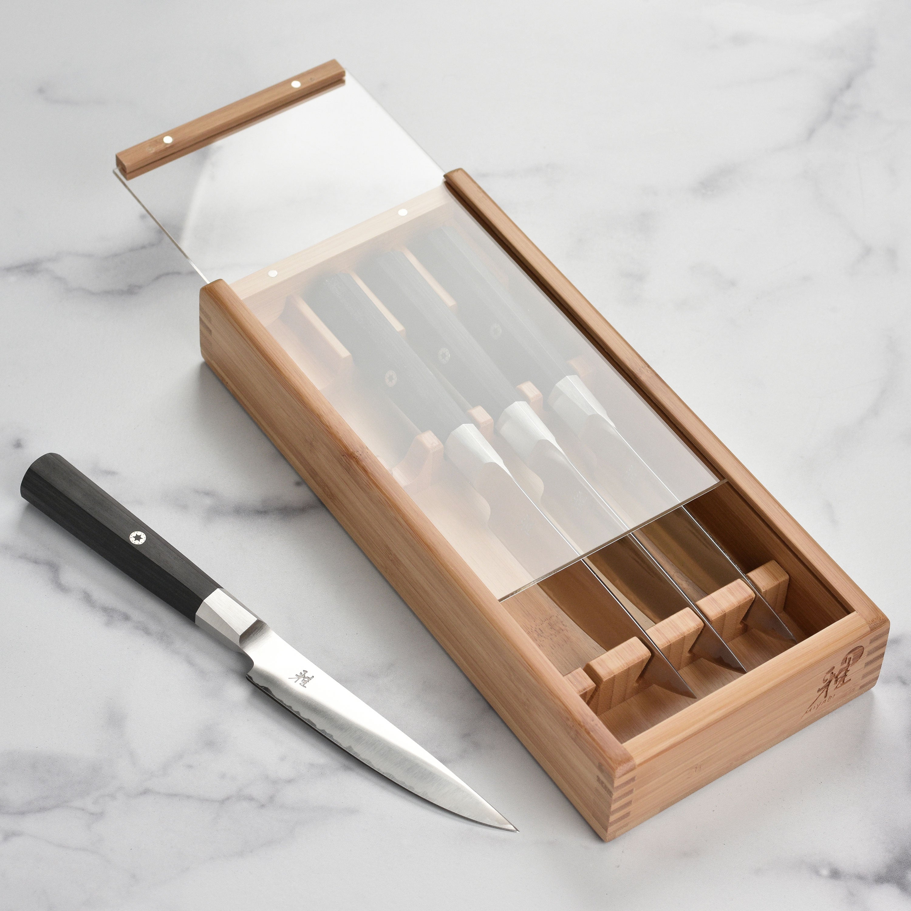 Miyabi Koh steak knife set displayed in a bamboo case, showcasing the sleek design and craftsmanship.