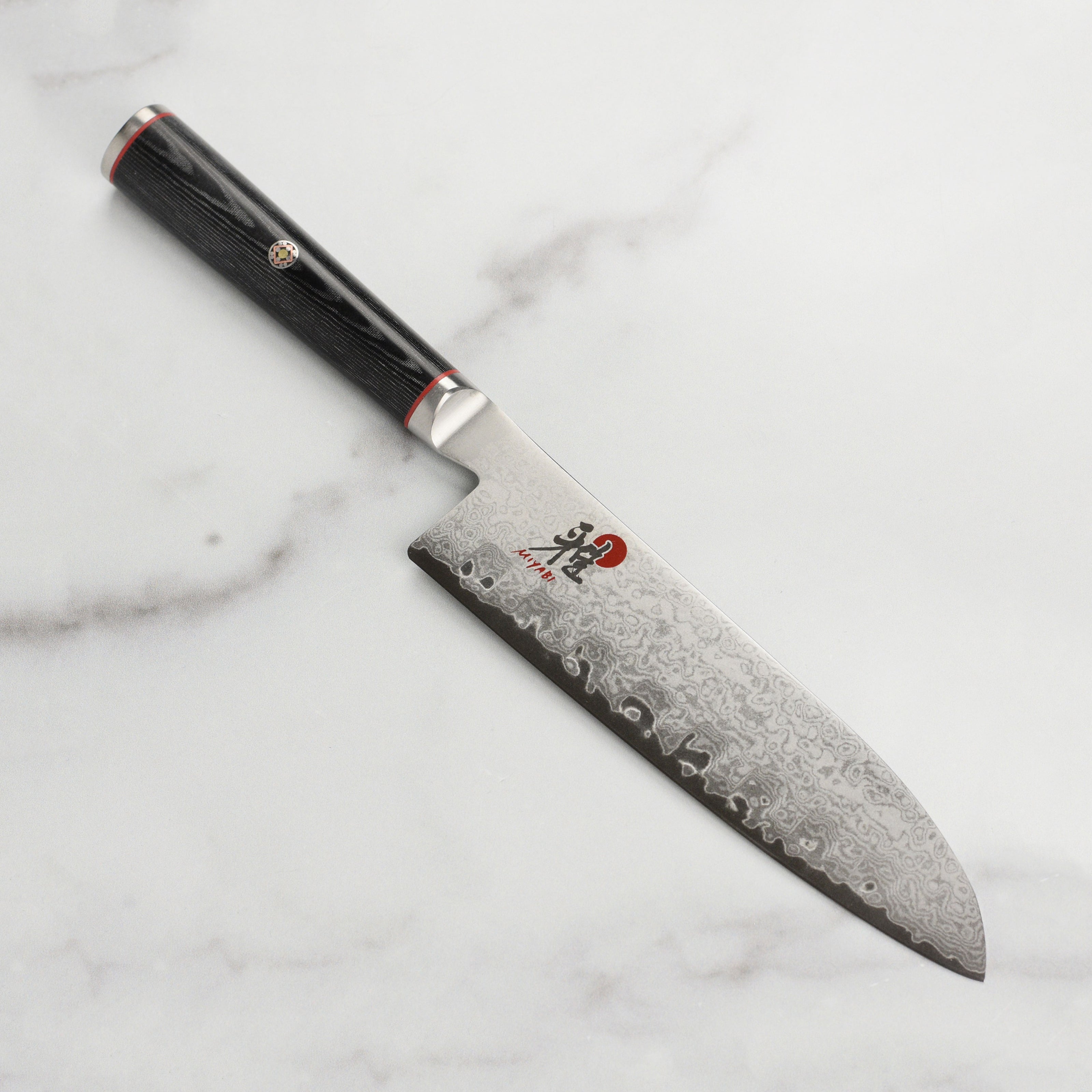 Miyabi Kaizen 5.5-inch hollow edge Santoku knife showcasing Damascus steel pattern and sharp blade.