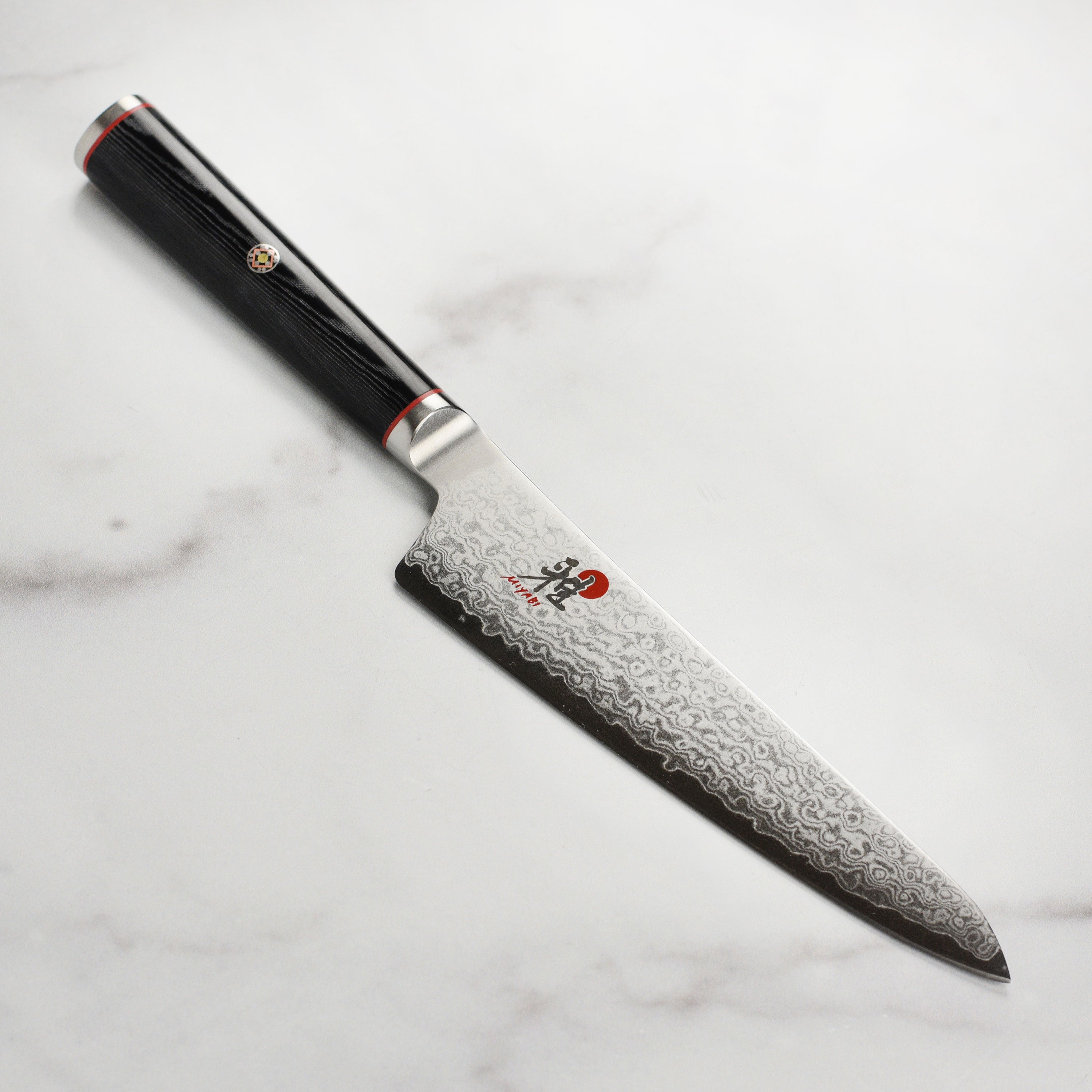 Miyabi Kaizen 5.5-inch Damascus prep knife showcasing the blade's intricate pattern.