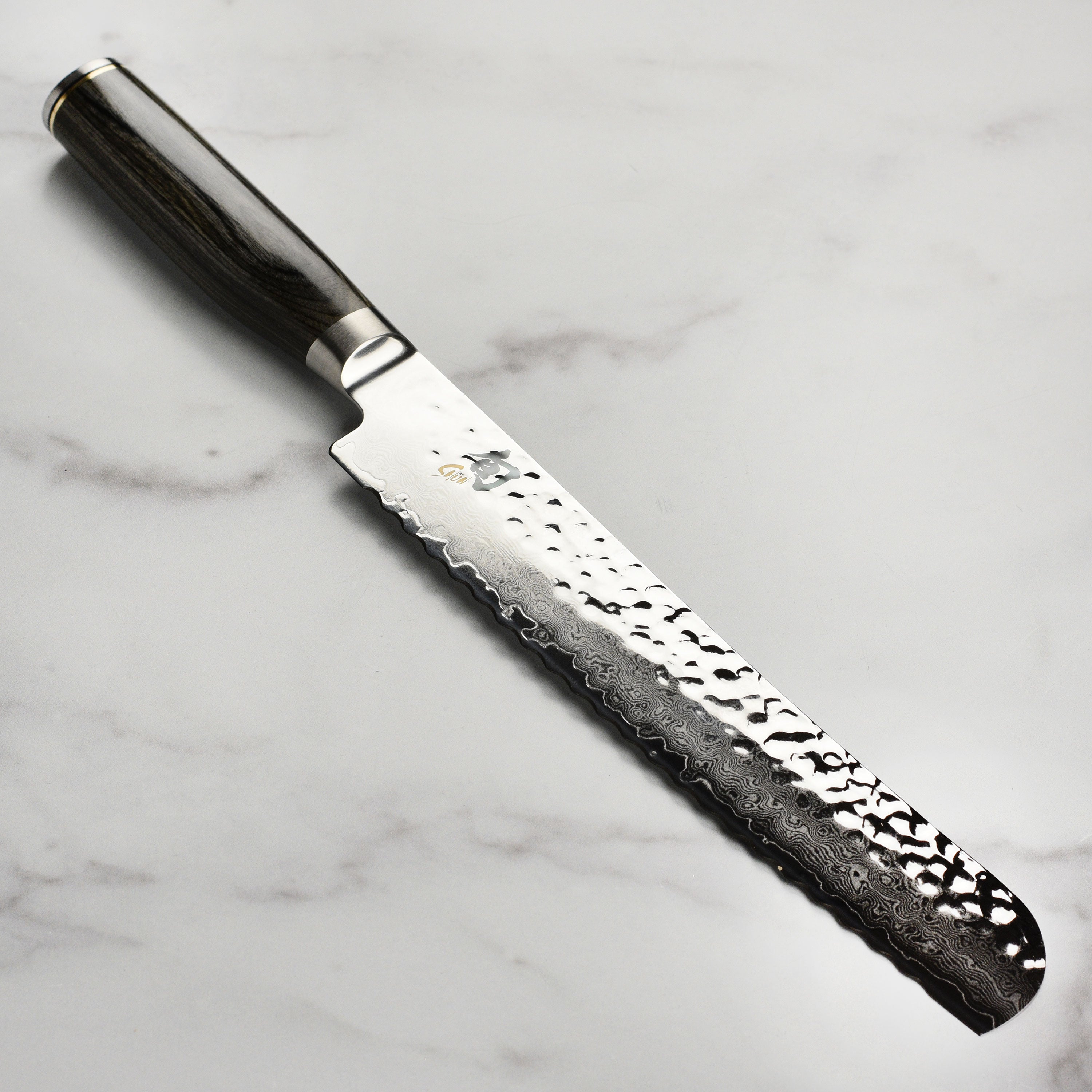 Damascus bread knife with textured blade and grey handle for crusty bread slicing