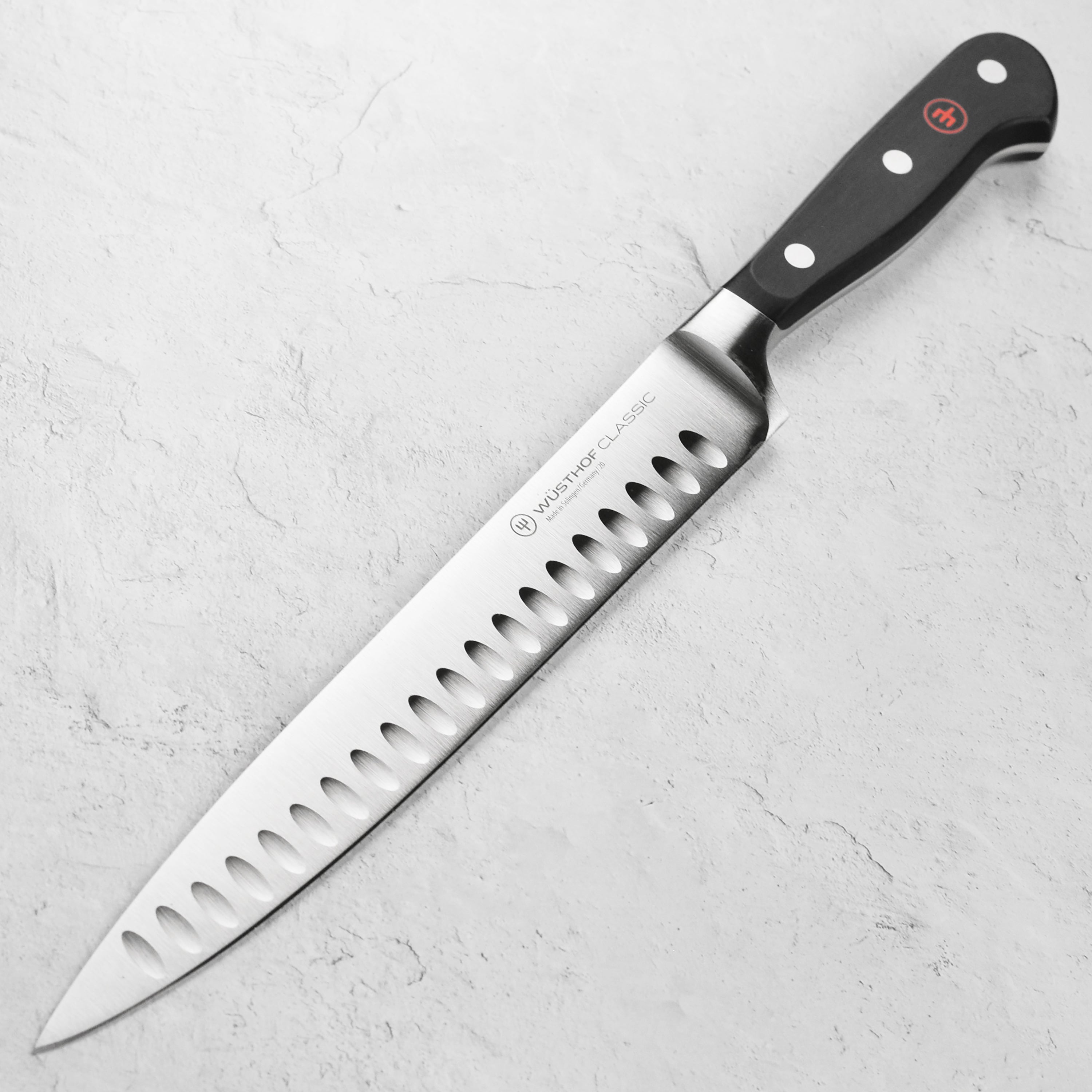Close-up of the Wusthof Classic 9-inch hollow edge carving knife blade showing sharpness and craftsmanship