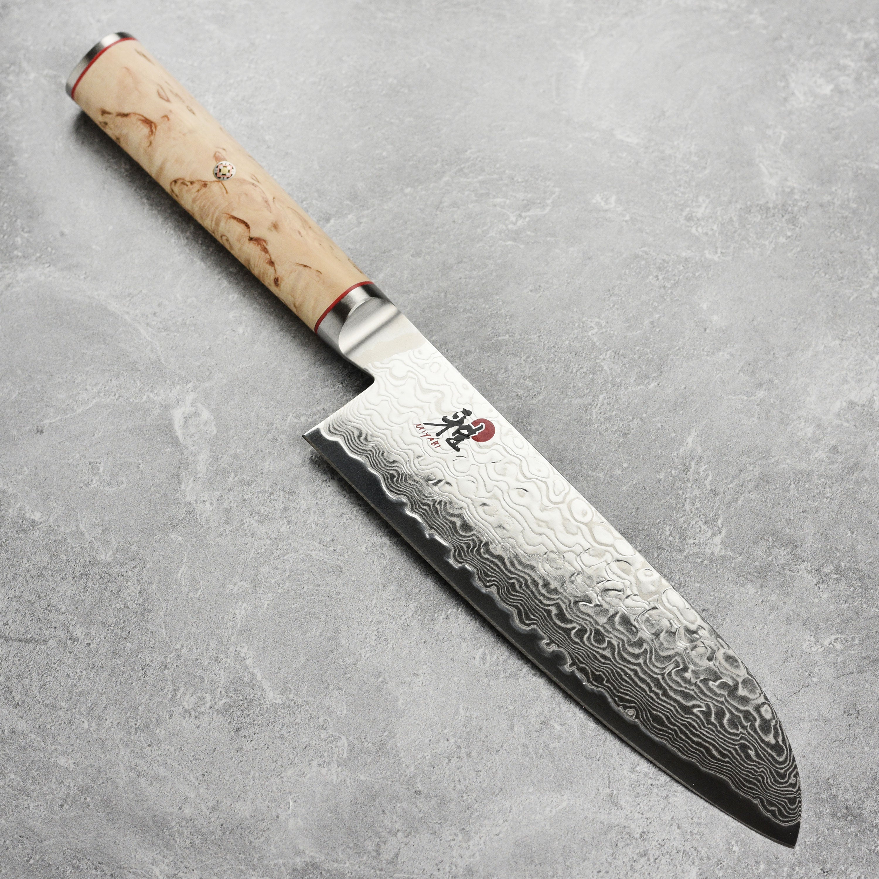 Miyabi Birchwood SG2 7-Inch Santoku Knife with a sharp edge and Damascus design from a side angle.