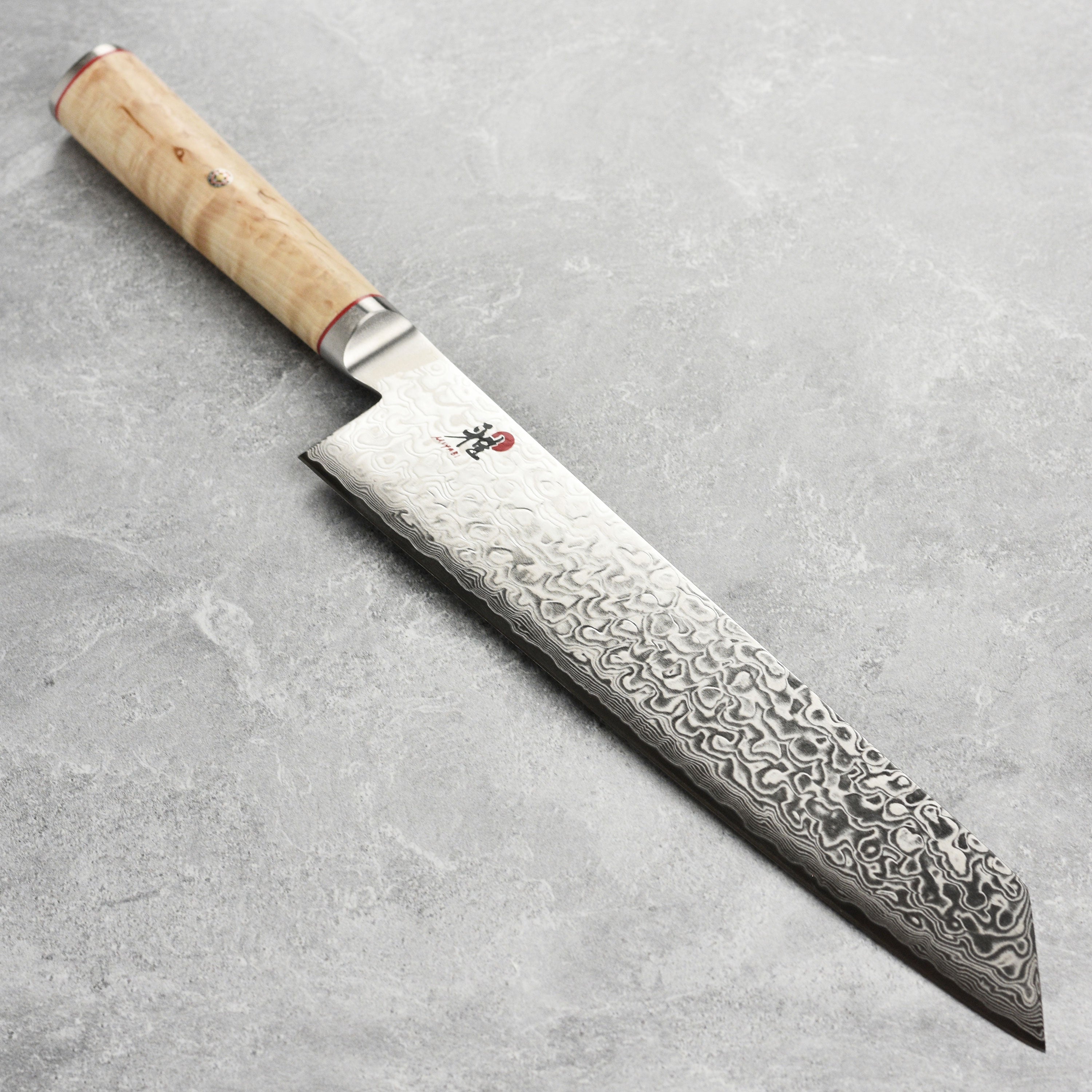 Close-up of Miyabi Damascus Kiritsuke knife blade with layered steel pattern