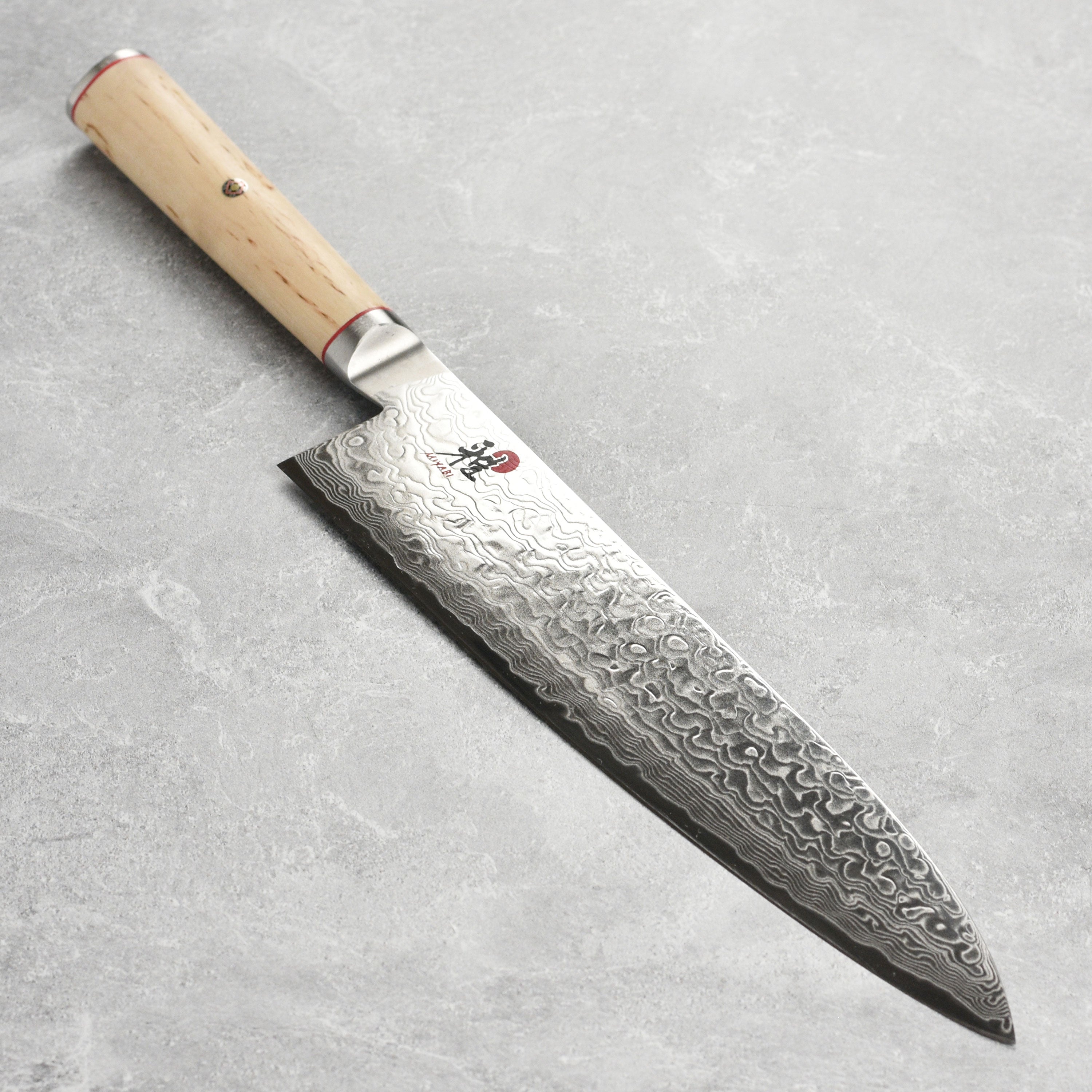 Miyabi Birchwood SG2 chef's knife showcasing its Damascus blade and Karelian Birchwood handle.